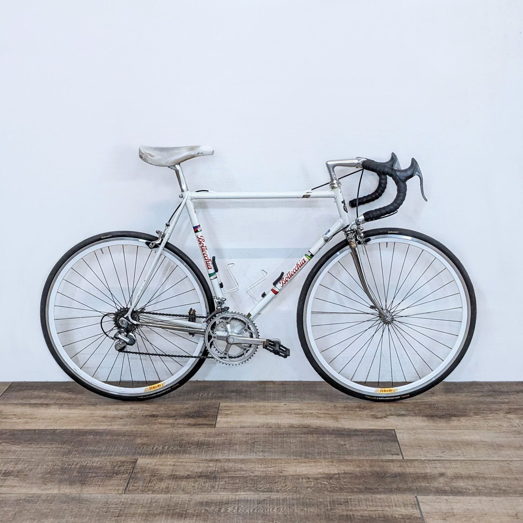Bottecchia road bike with sturdy frame and reliable brakes, ideal for long rides and commutes, against a white wall.