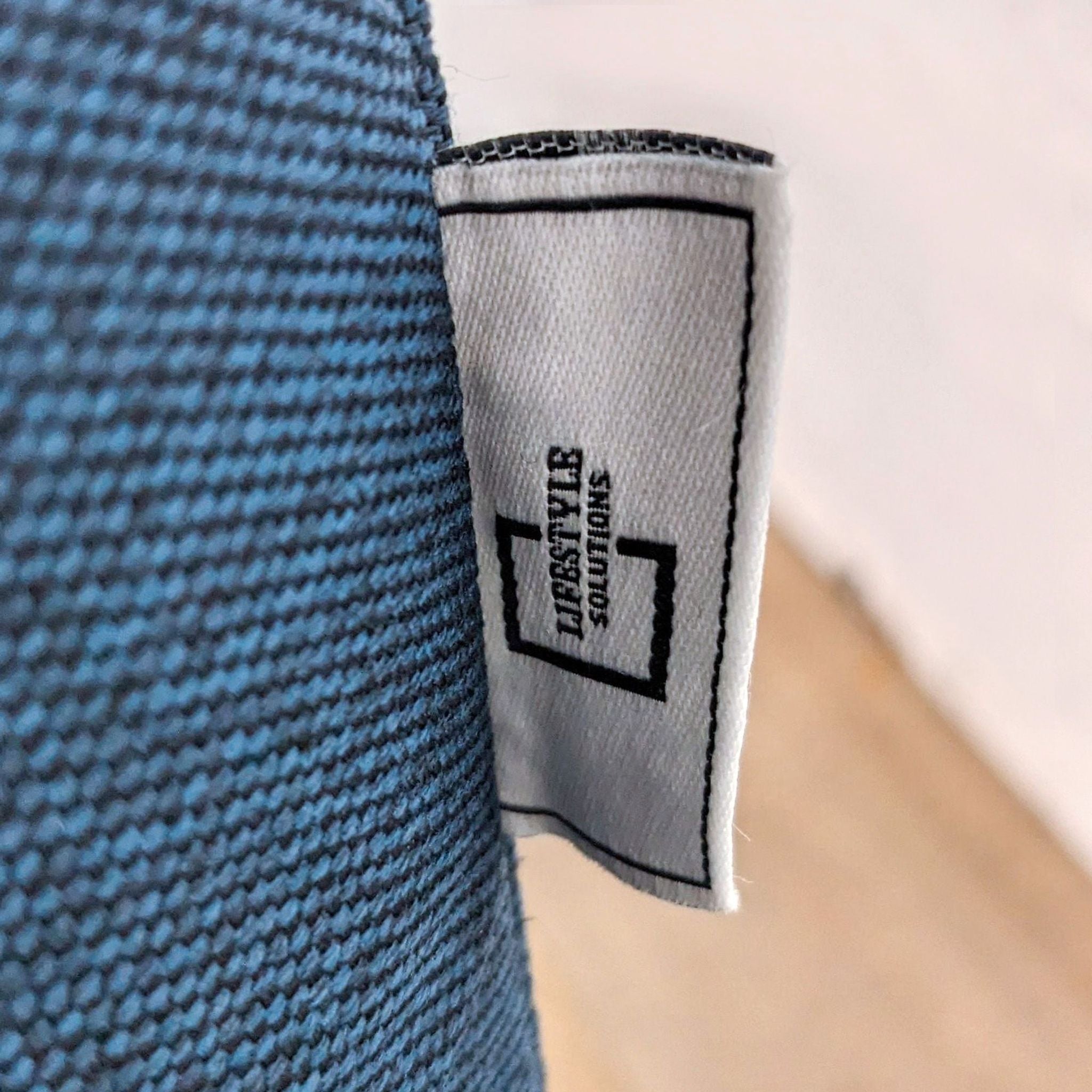 Close-up of a blue fabric with a Lifestyle Solutions brand tag.