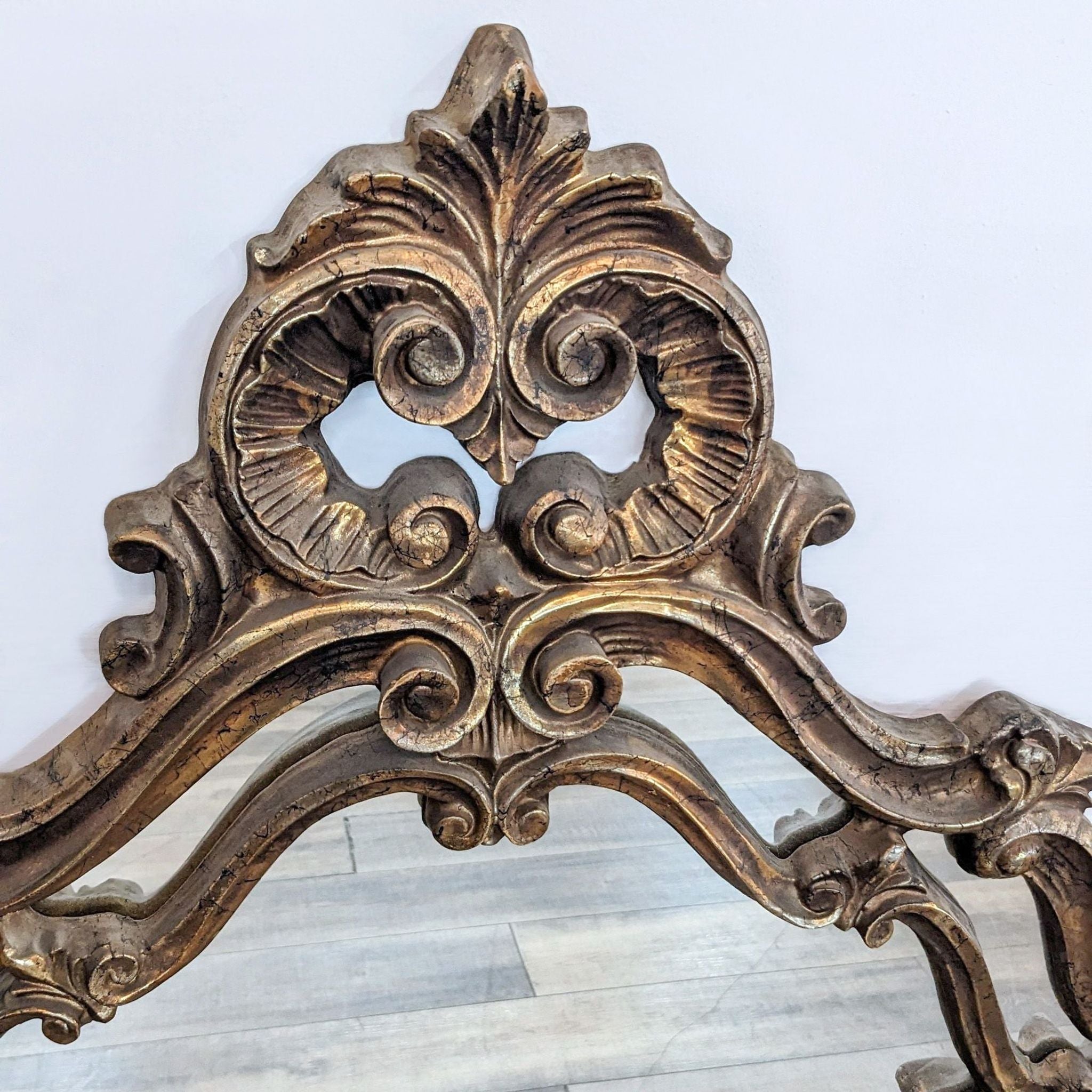 Close-up of Reperch mirror detailing, showcasing elaborate carved designs in the antique gold frame.