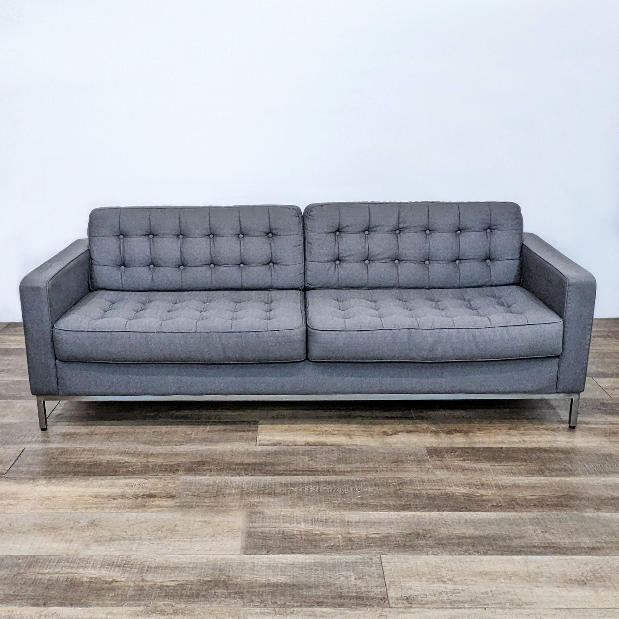 EQ3 brand charcoal fabric 3-seat tailored sofa with button tufted seat and back, narrow arms on chrome frame.