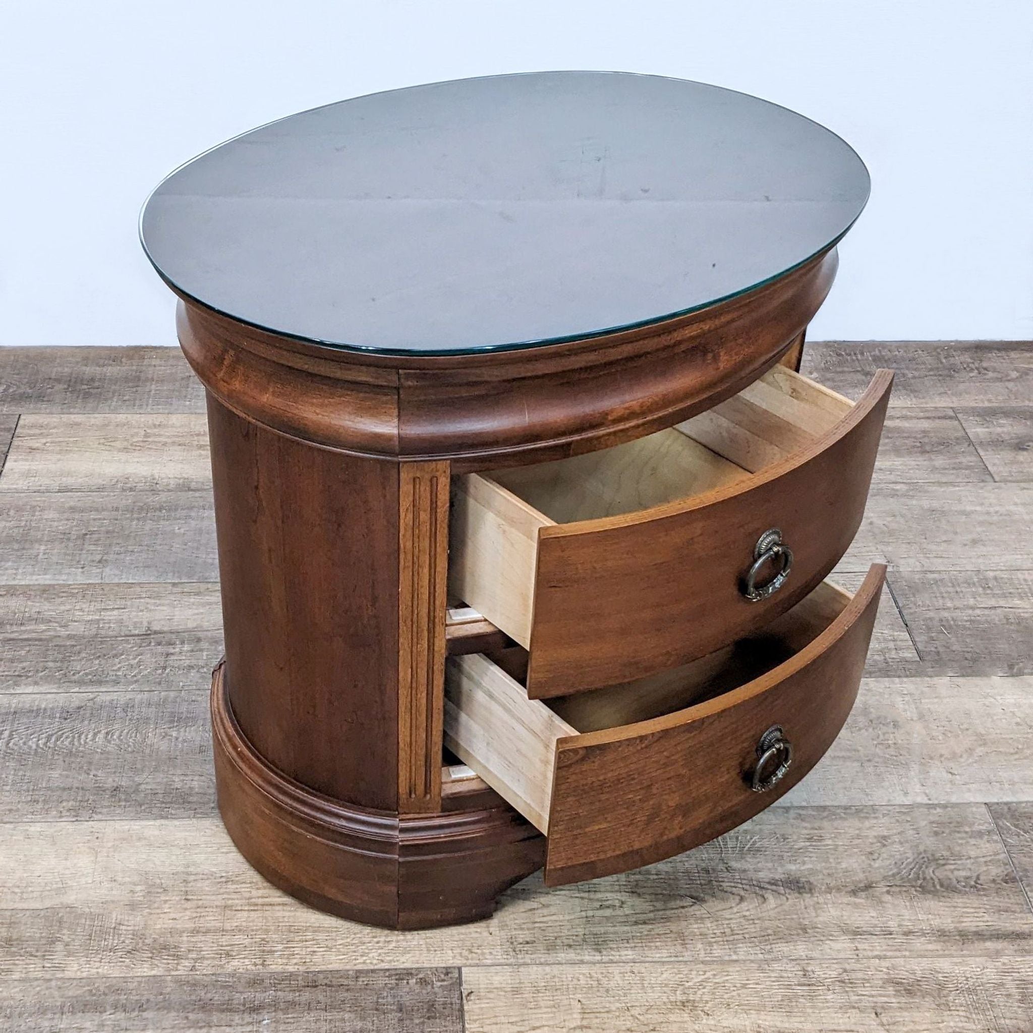 Open drawers of a Reperch end table showcasing storage, with glass top and a wooden base.