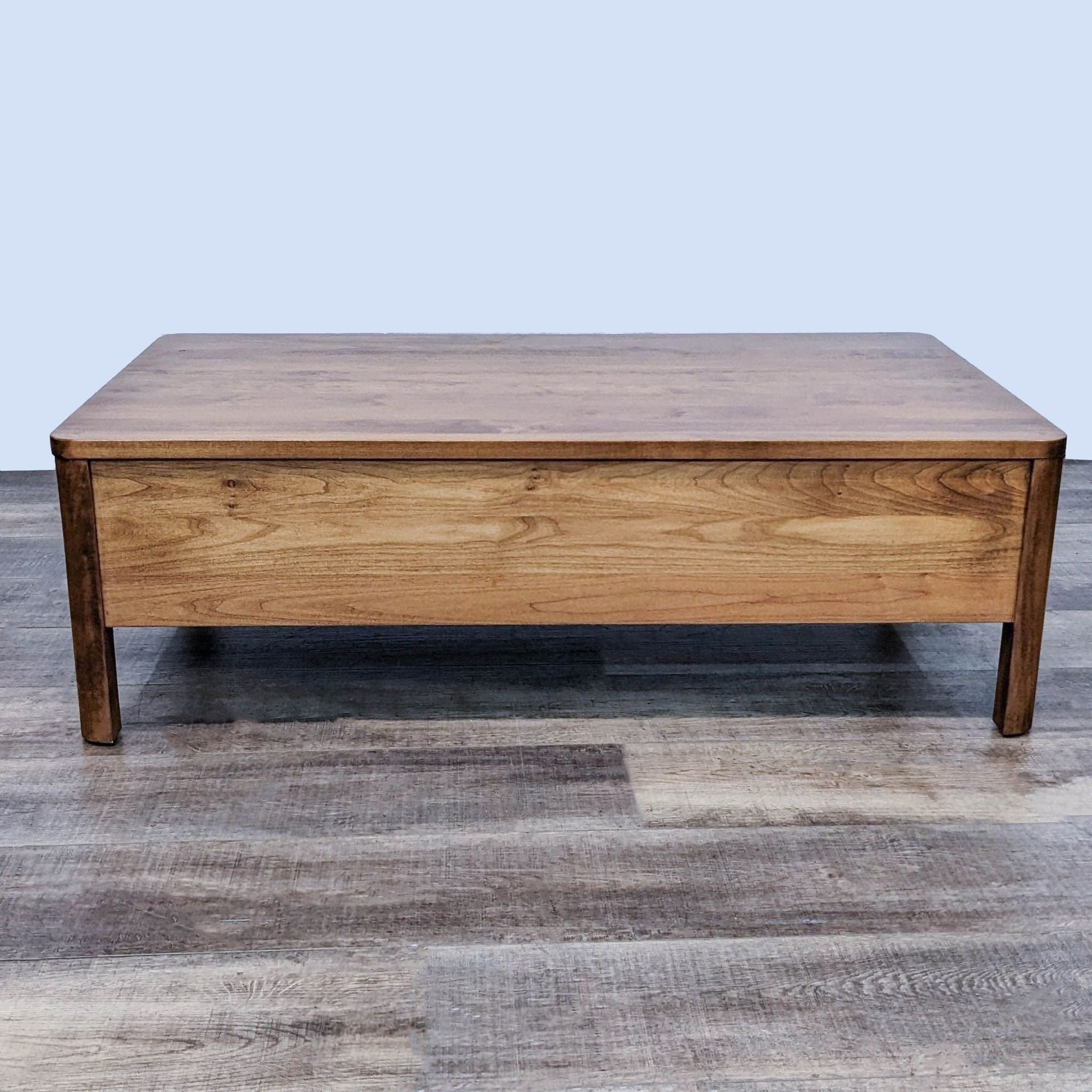 Warm natural finish Wood Castle coffee table with two drawers on a wooden floor.