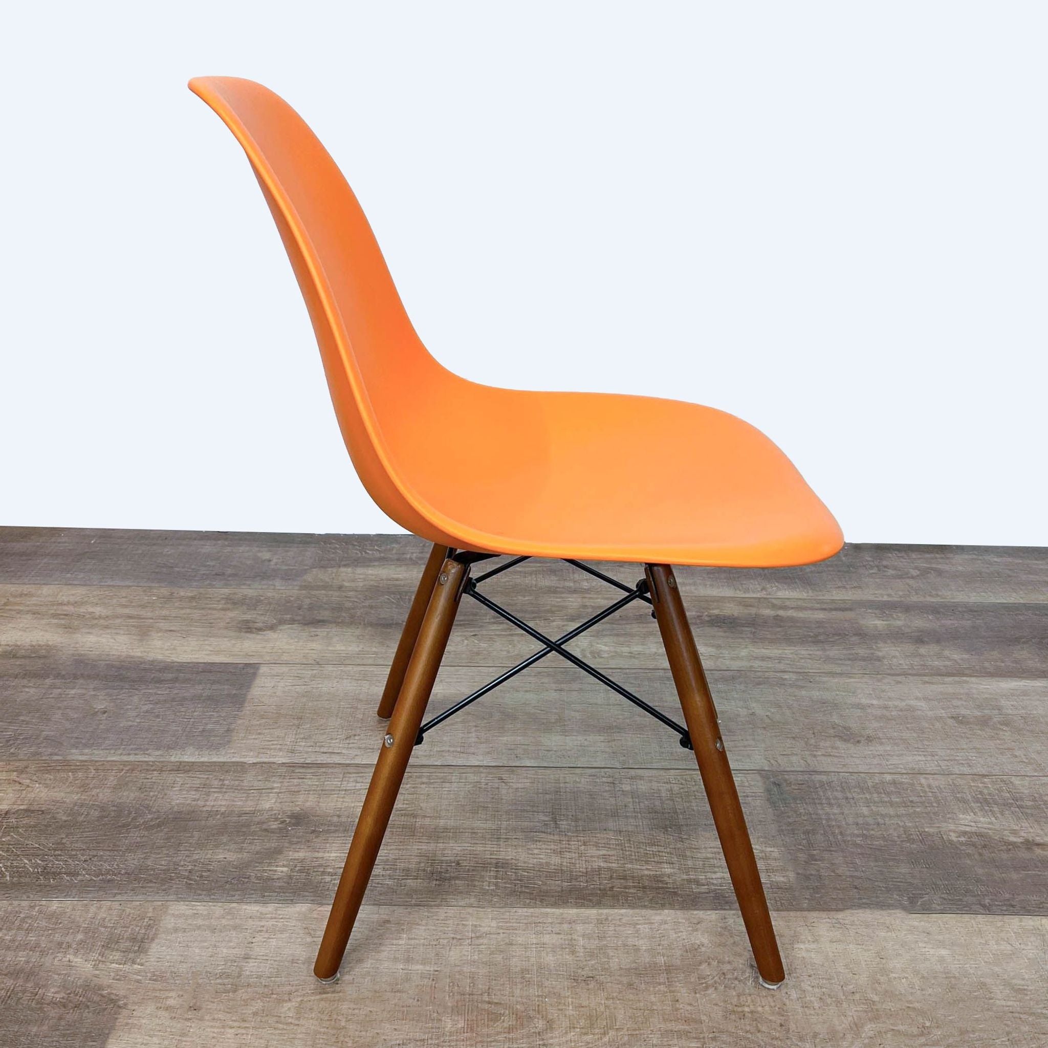 Modern Reperch orange polypropylene chair with a distinctive Eifel base, positioned on wooden flooring.