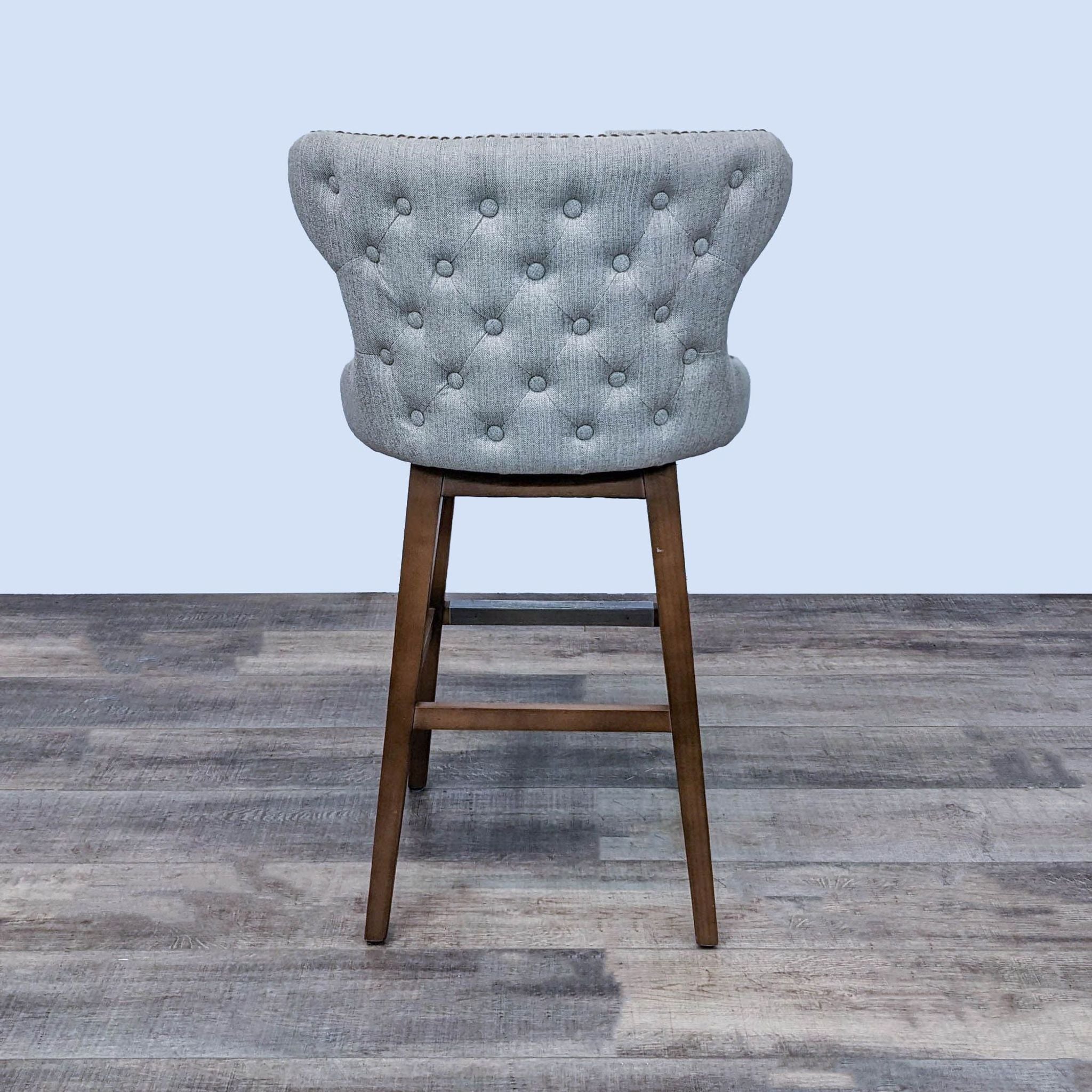 Reperch branded tufted back fabric bar stool with nail head detail on wood frame.