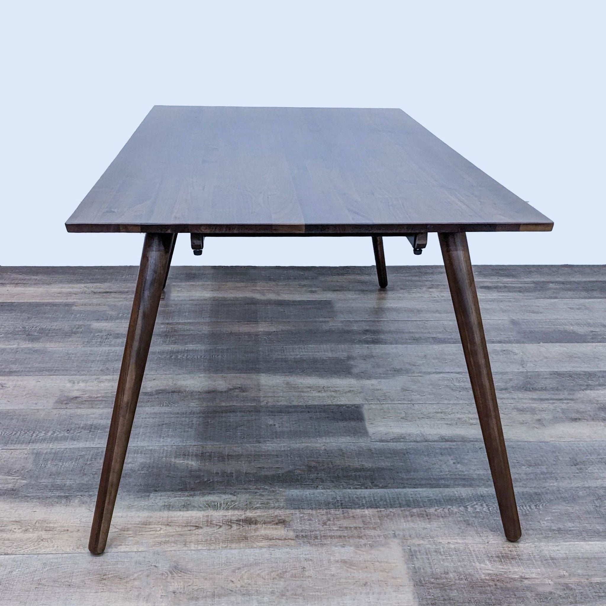 Seno Dining Table by Article, featuring clean lines, walnut finish, and angled legs for a retro modern touch.