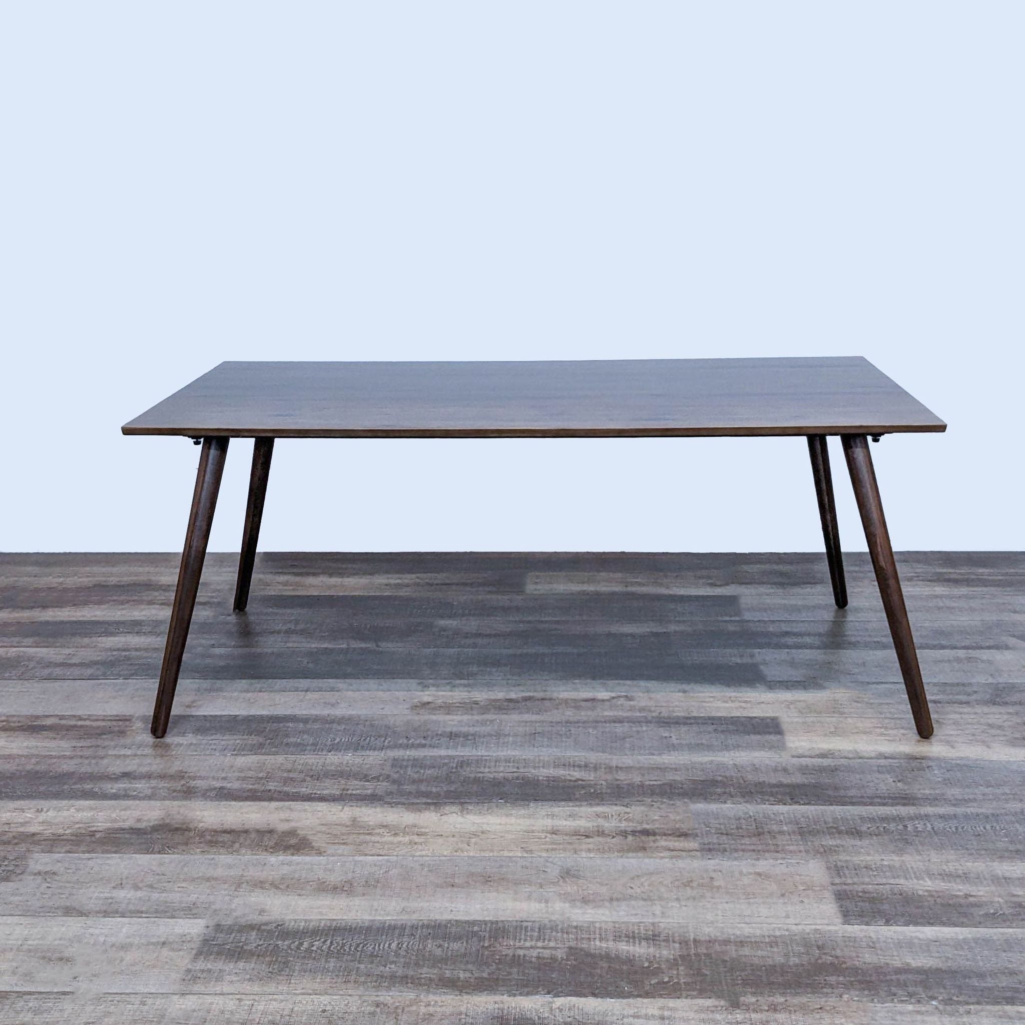 Article Seno Dining Table with tapered wood legs and a smooth top, exhibiting mid-century modern style.