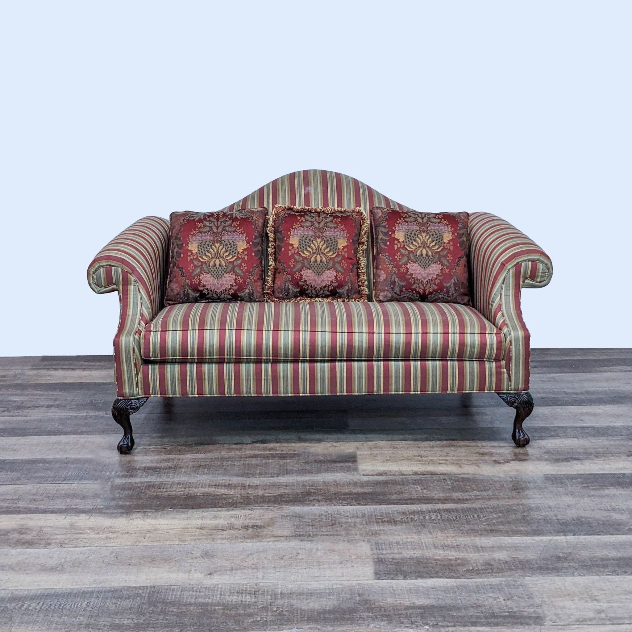 Ethan Allen traditional striped fabric loveseat with Queen Anne silhouette, Chippendale feet, and three ornate pillows.