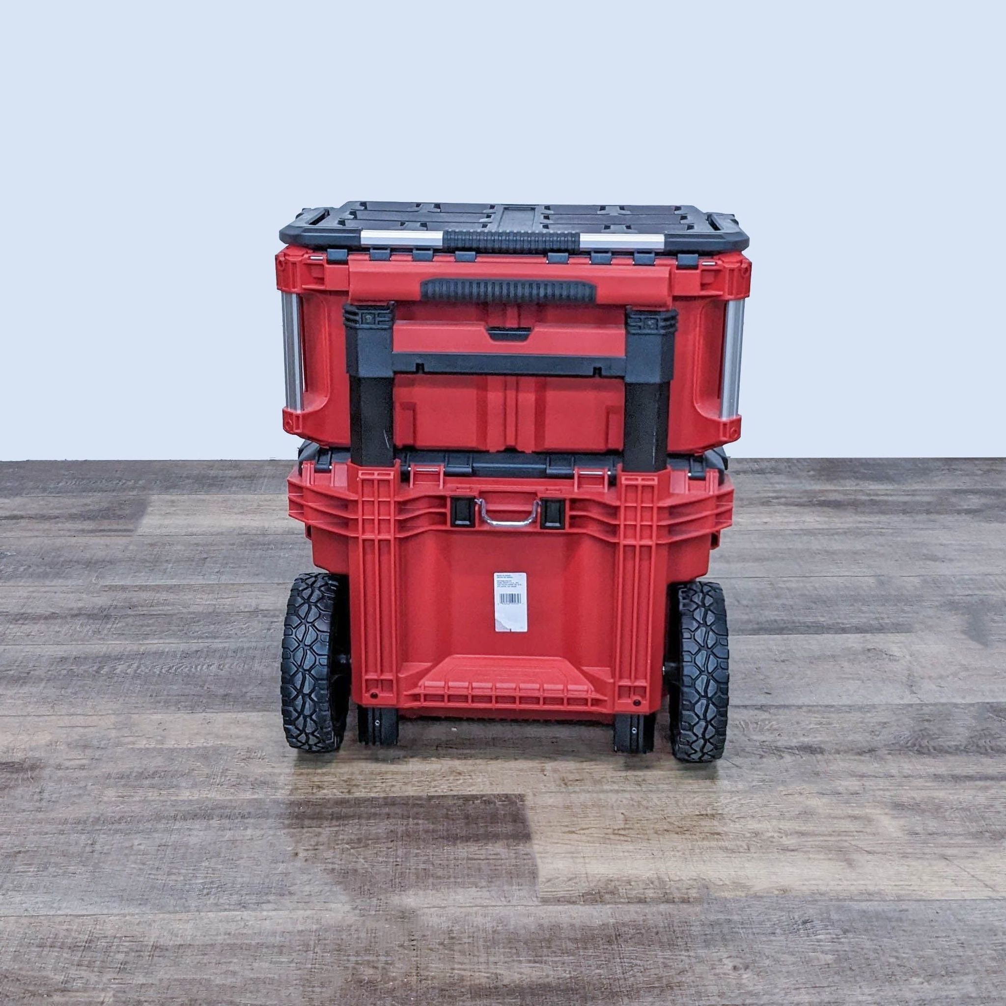 Rear view of Milwaukee PACKOUT tool boxes with durable wheels and telescoping handle for easy transportation.