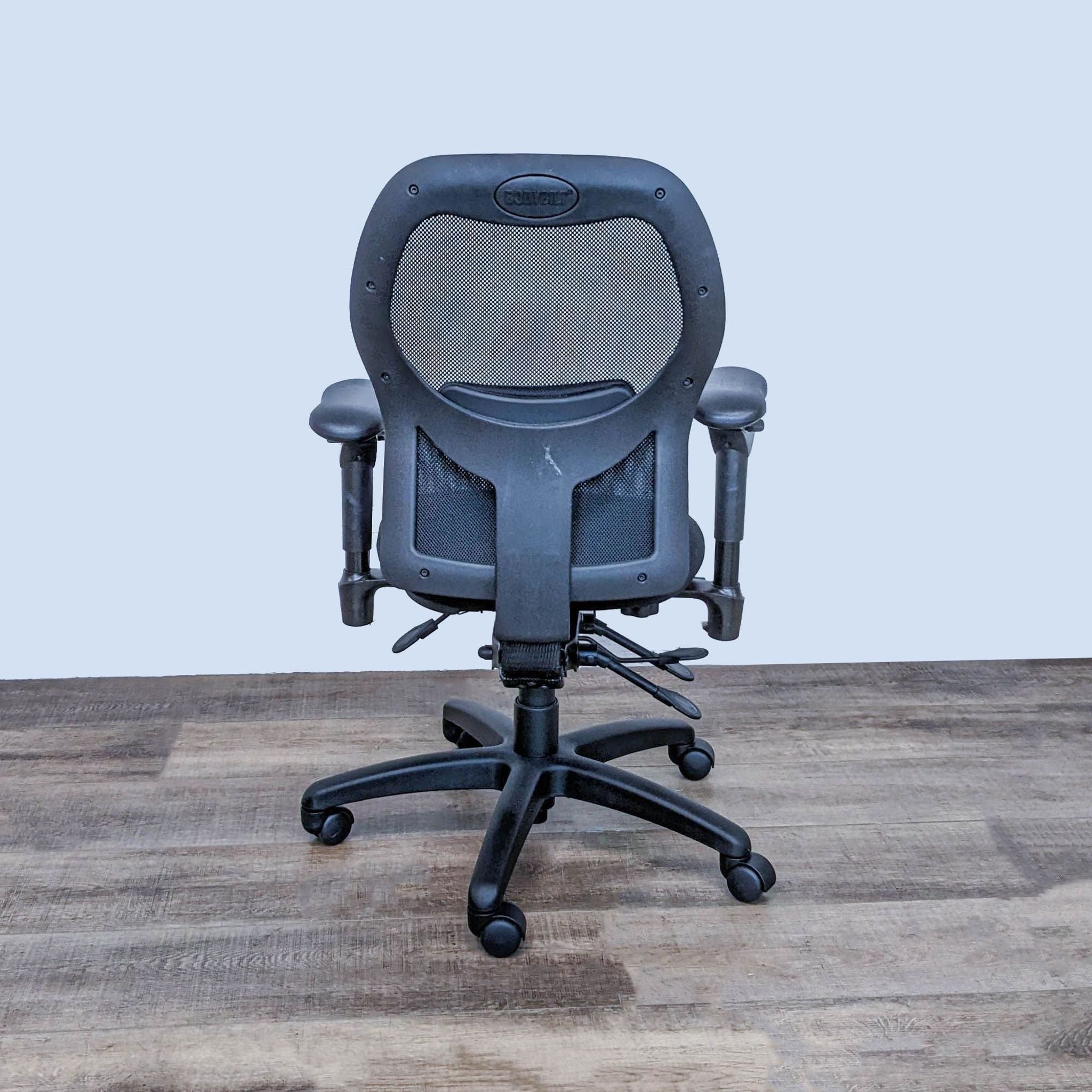 Bodybilt ergonomic office chair with mesh back, lumbar support, and adjustable armrests on a wooden floor.