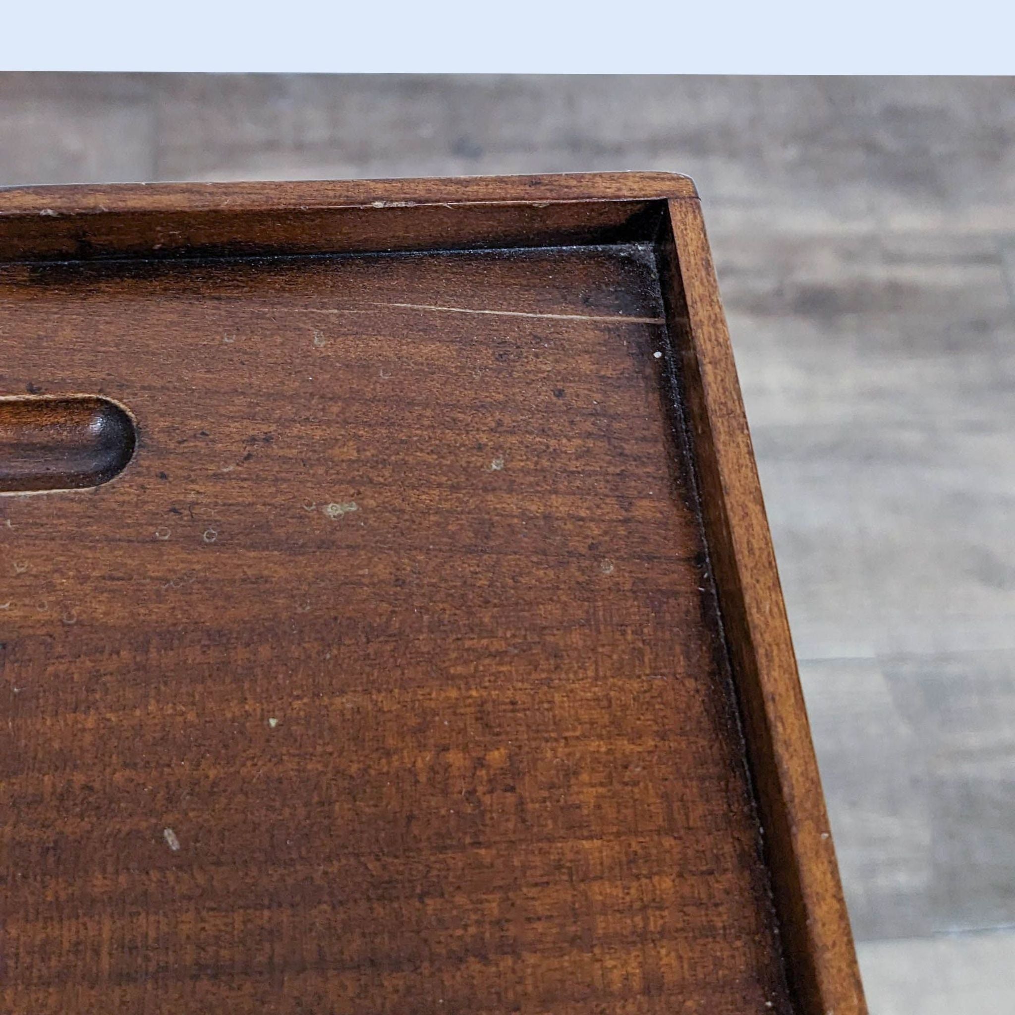 Close-up of a vintage Reperch chest drawer with dovetail joinery and a wooden texture.