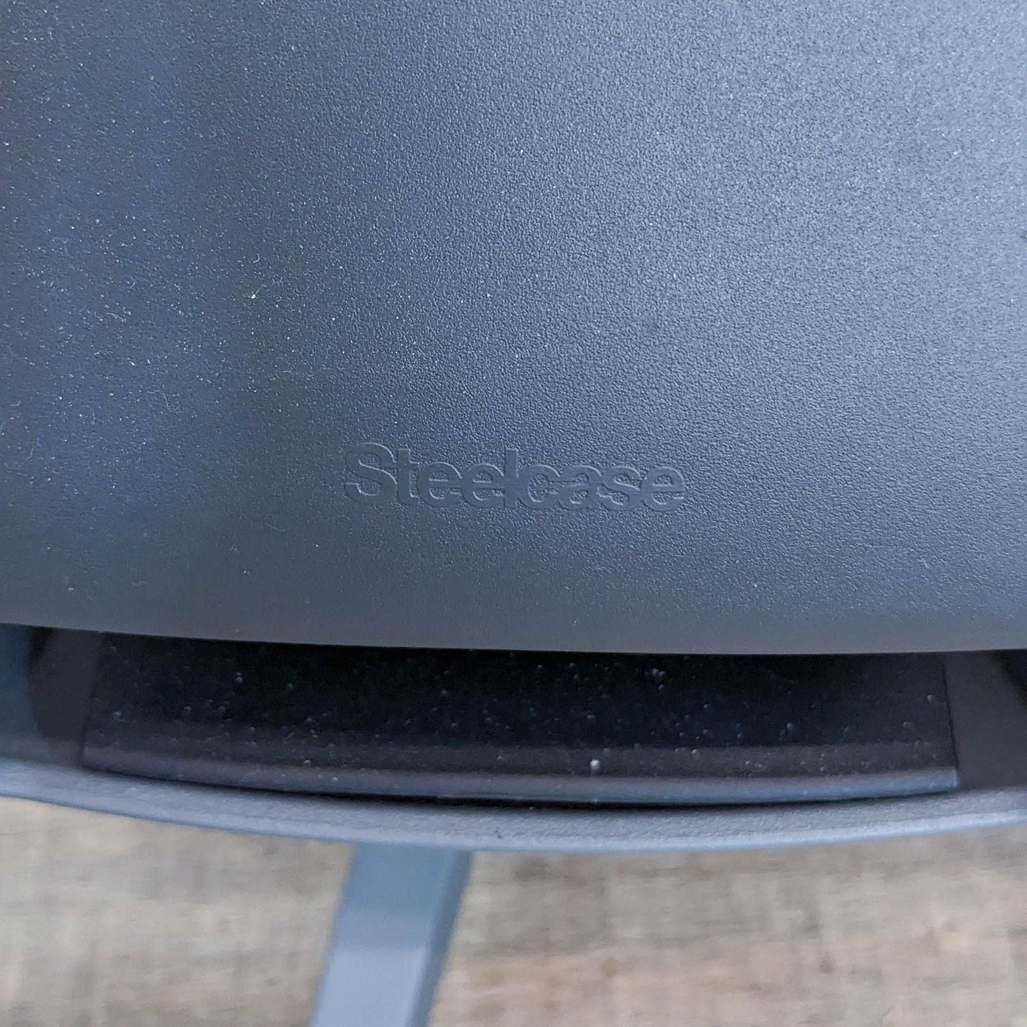 Close-up of the Steelcase logo on the back of a Gesture office chair with textured finish.