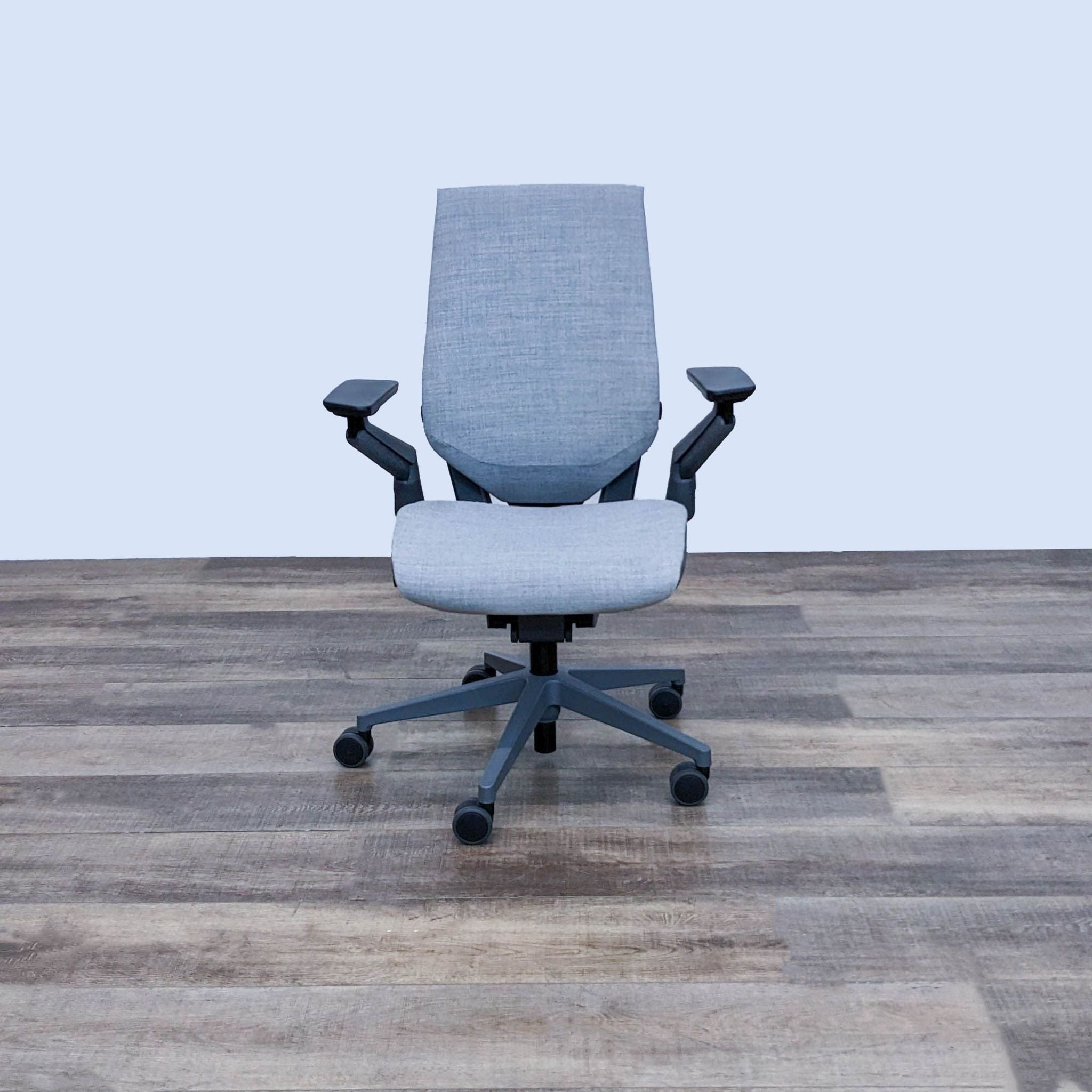 Steelcase Gesture office chair with adjustable arms and seat, pneumatic height adjustment, and recline features on a hard floor.