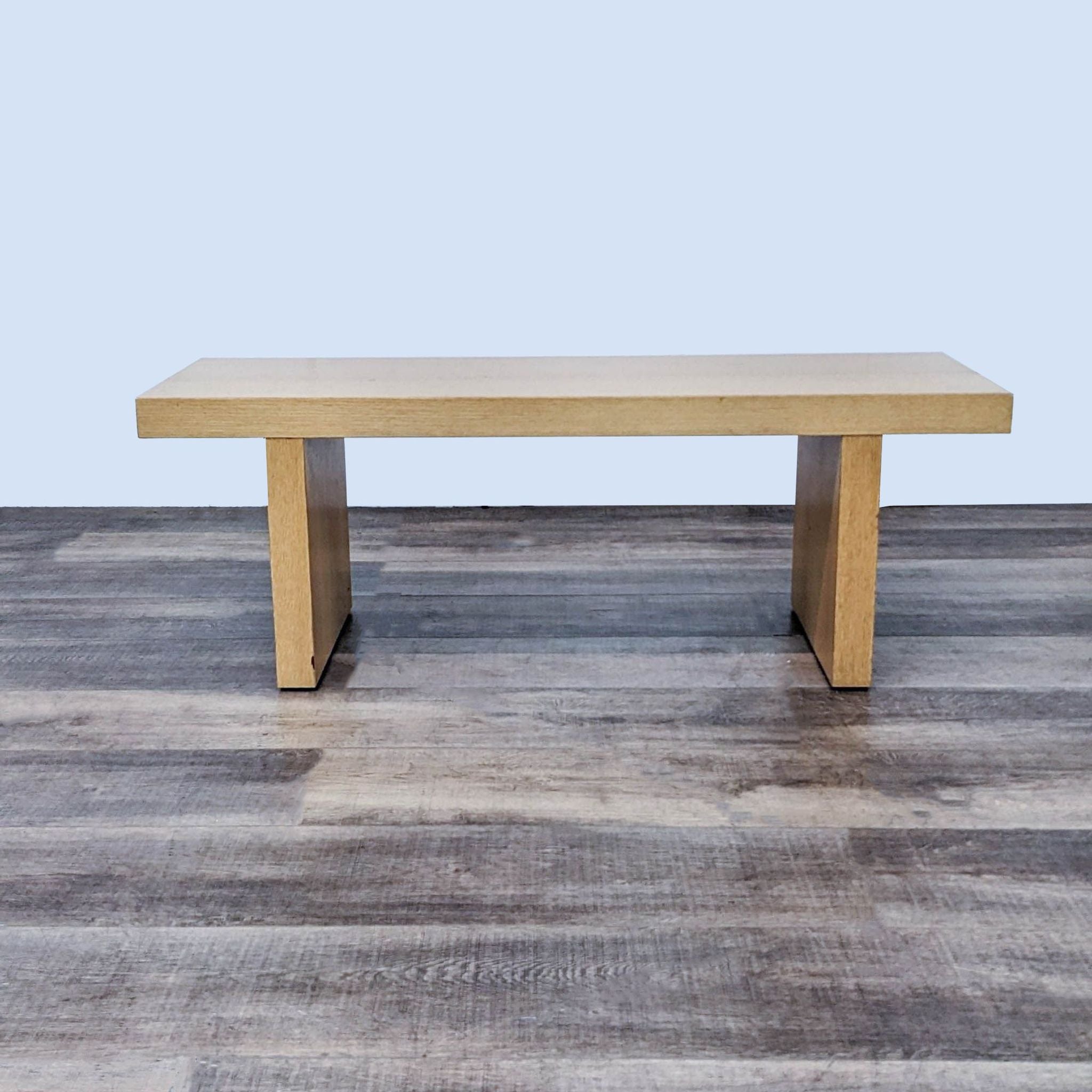 Reperch brand modern beech-colored bench with a clean silhouette, placed on a wooden floor.