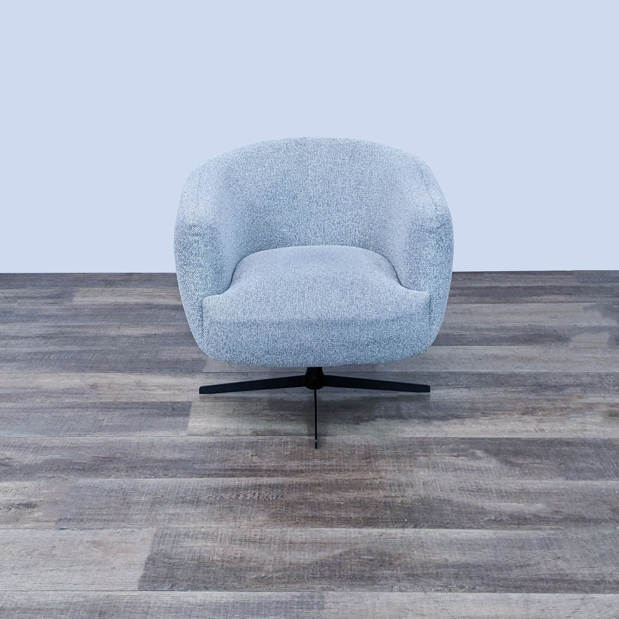 Contemporary Target lounge chair with textured light grey fabric and smooth swivel base on wooden flooring.