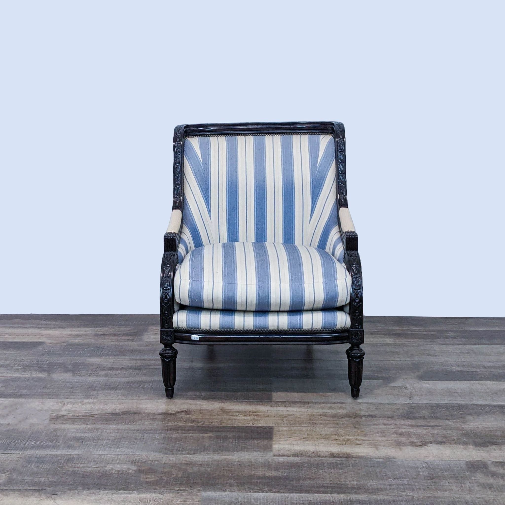 Marge Carson striped lounge chair with nailhead trim and carved wood frame details, on a wood floor.