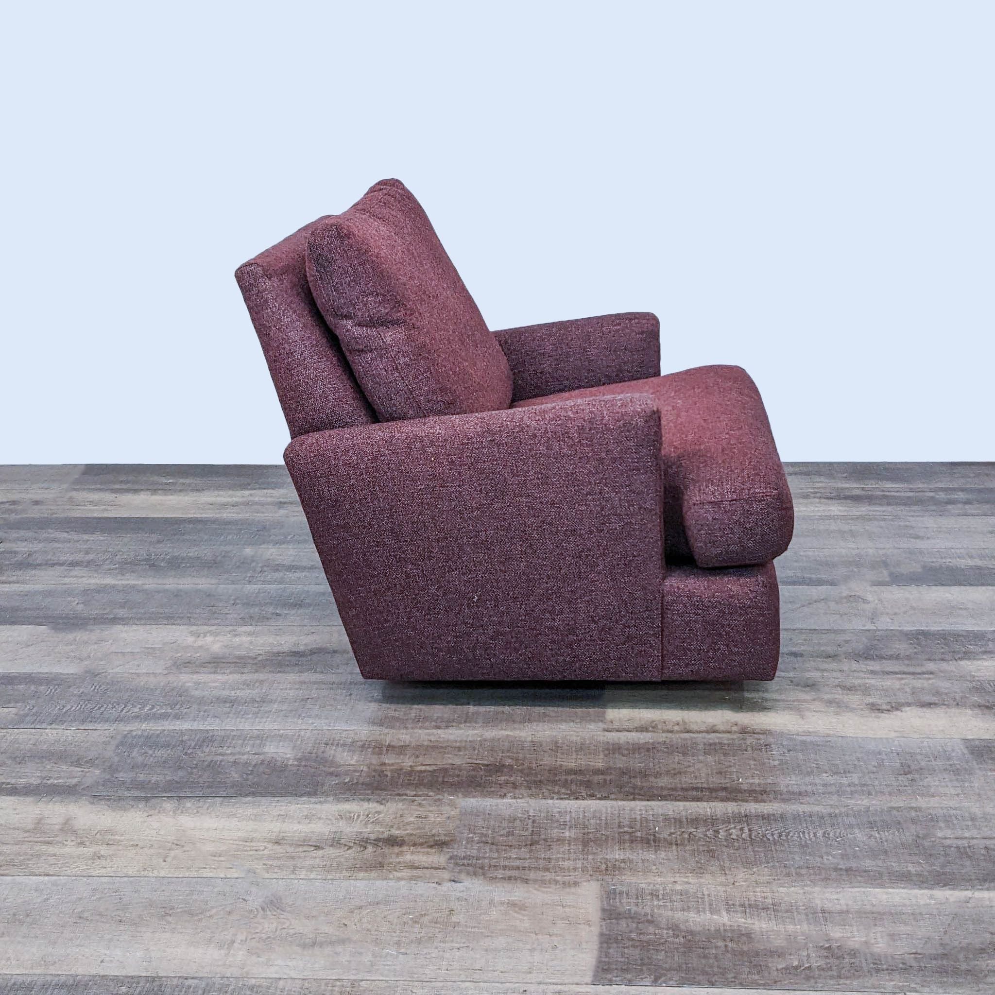 Room & Board swivel glider lounge chair, side angle view, showcasing the linen fabric upholstery in burgundy on a wooden floor.