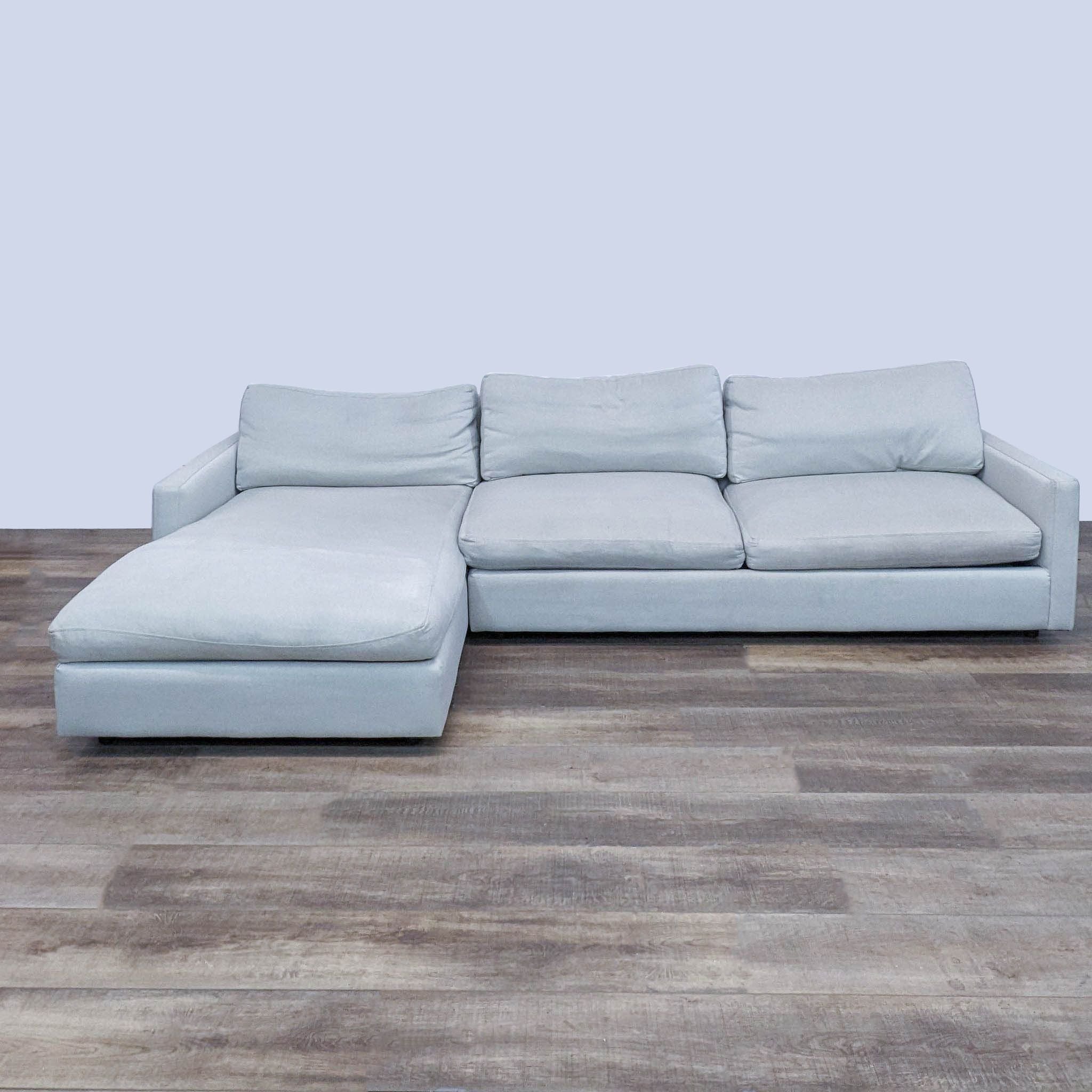 Room & Board sleek sectional in neutral color with chaise and narrow arms, positioned on a wooden floor.
