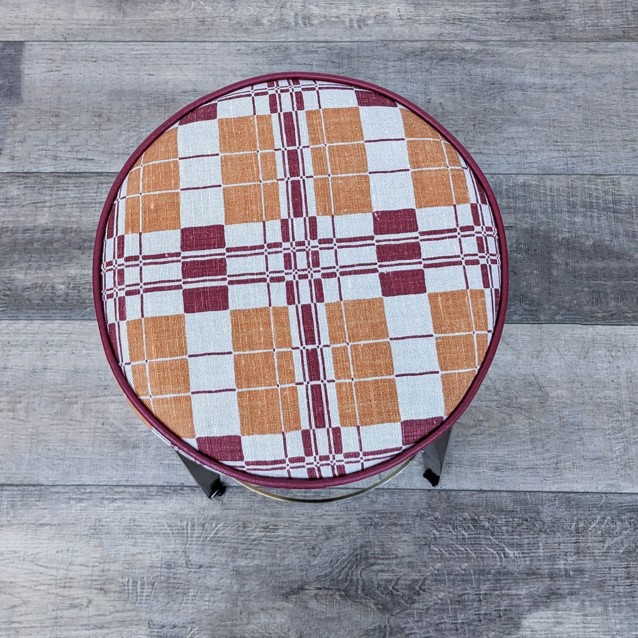 Round Reperch stool showcasing a bright, geometric design fabric cushion on a bronze-finished base.