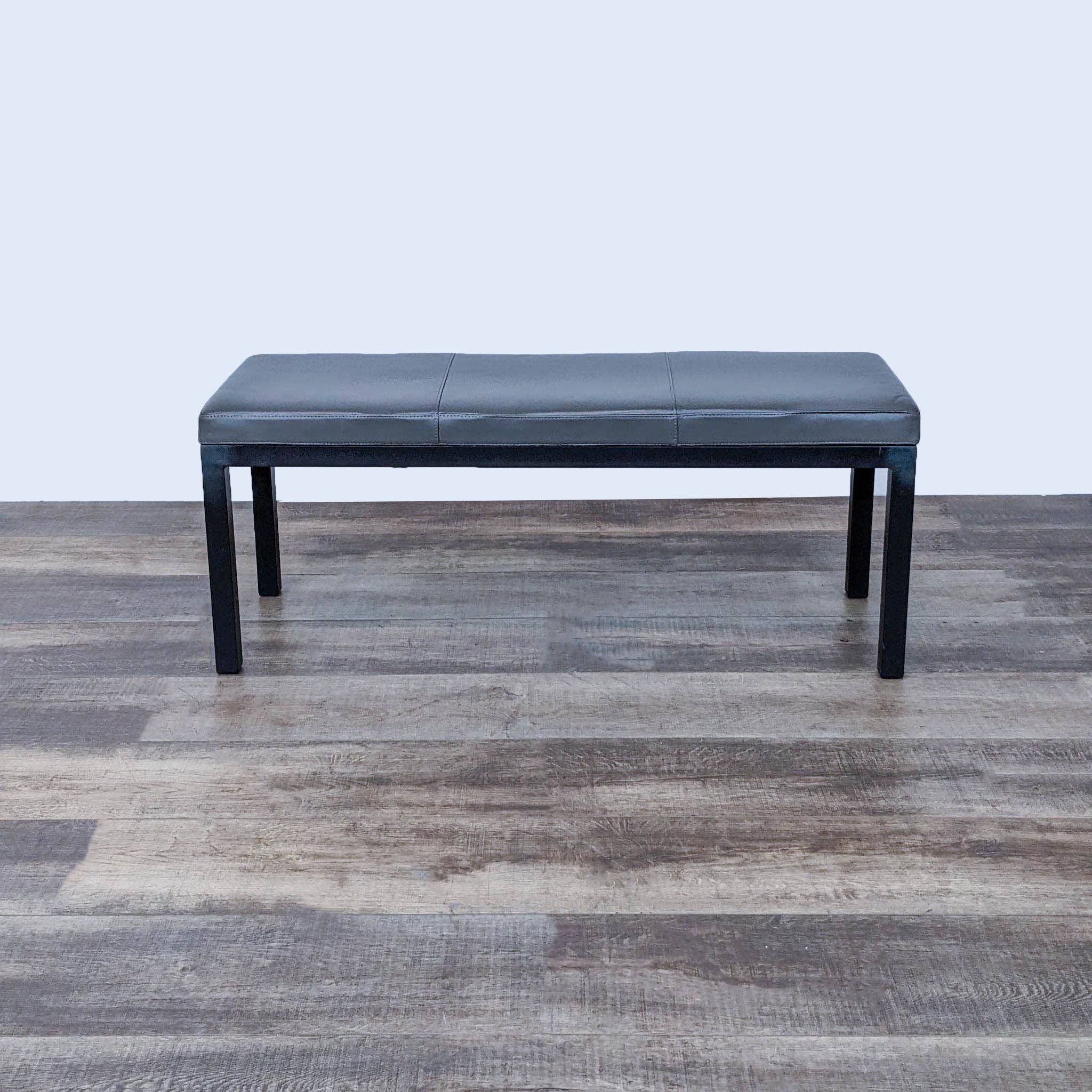 Reperch solid wood frame bench with a neutral padded seat on a wooden floor.
