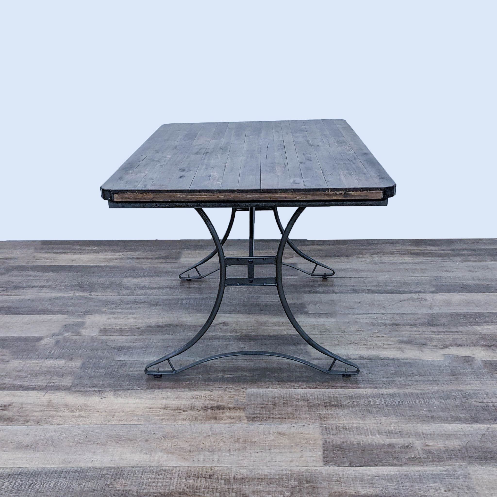 Cost Plus World Market's Jackson dining table, displaying a solid wooden top with dark finish and sturdy metal base.