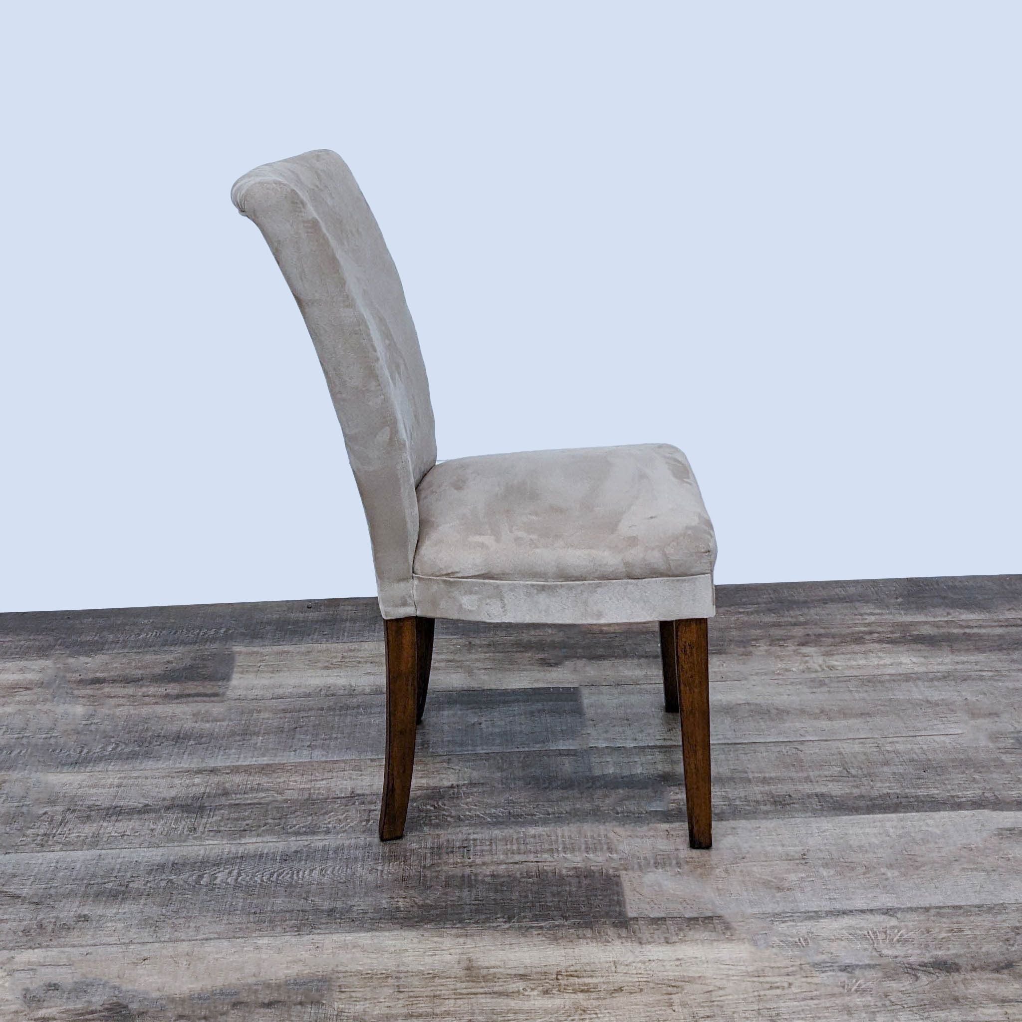 Side view of Reperch Parsons style chair in faux suede upholstery with wood legs against a wooden floor.