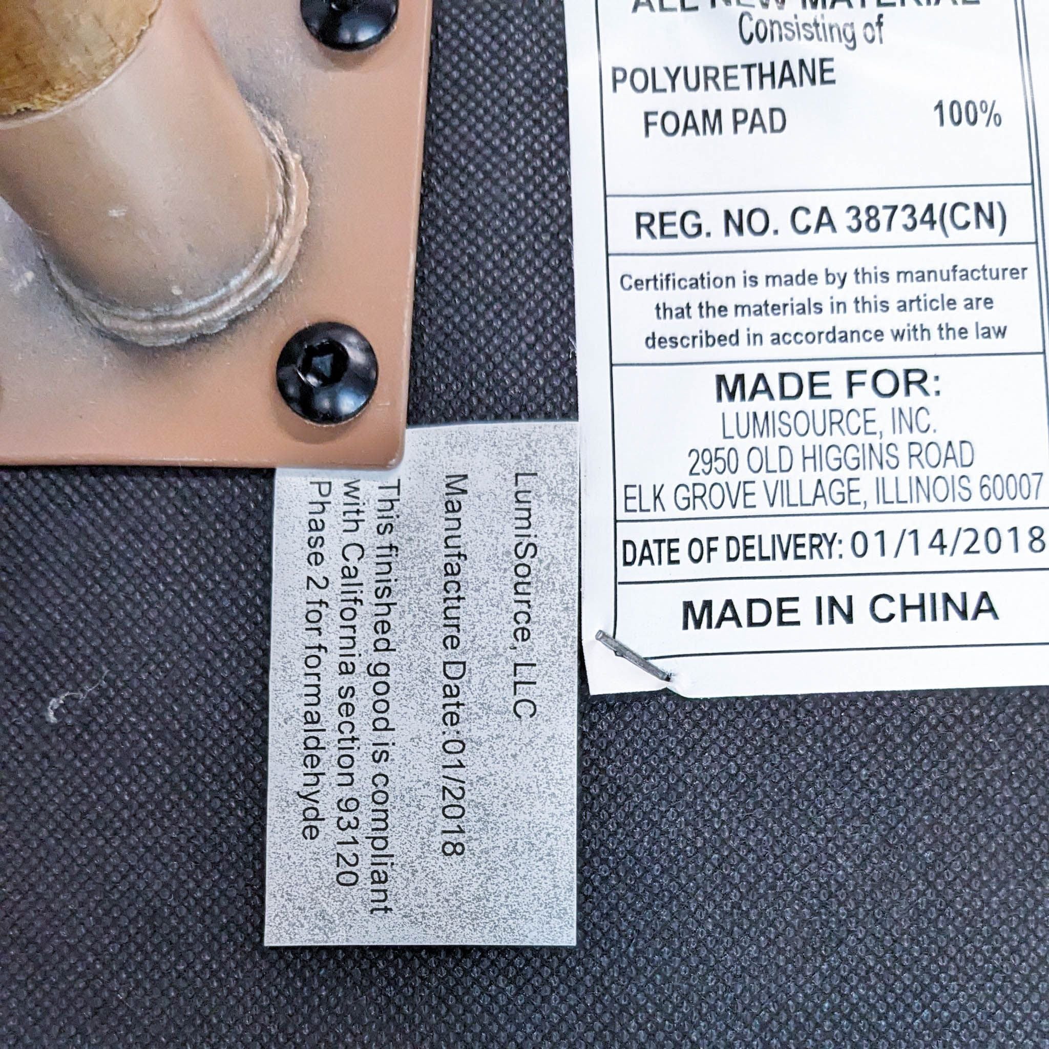 Alt text 2: Close-up of a manufacturing label on a Vintage Flair Chair by LumiSource indicating materials, compliance, and the production date along with the "Made in China" marking.