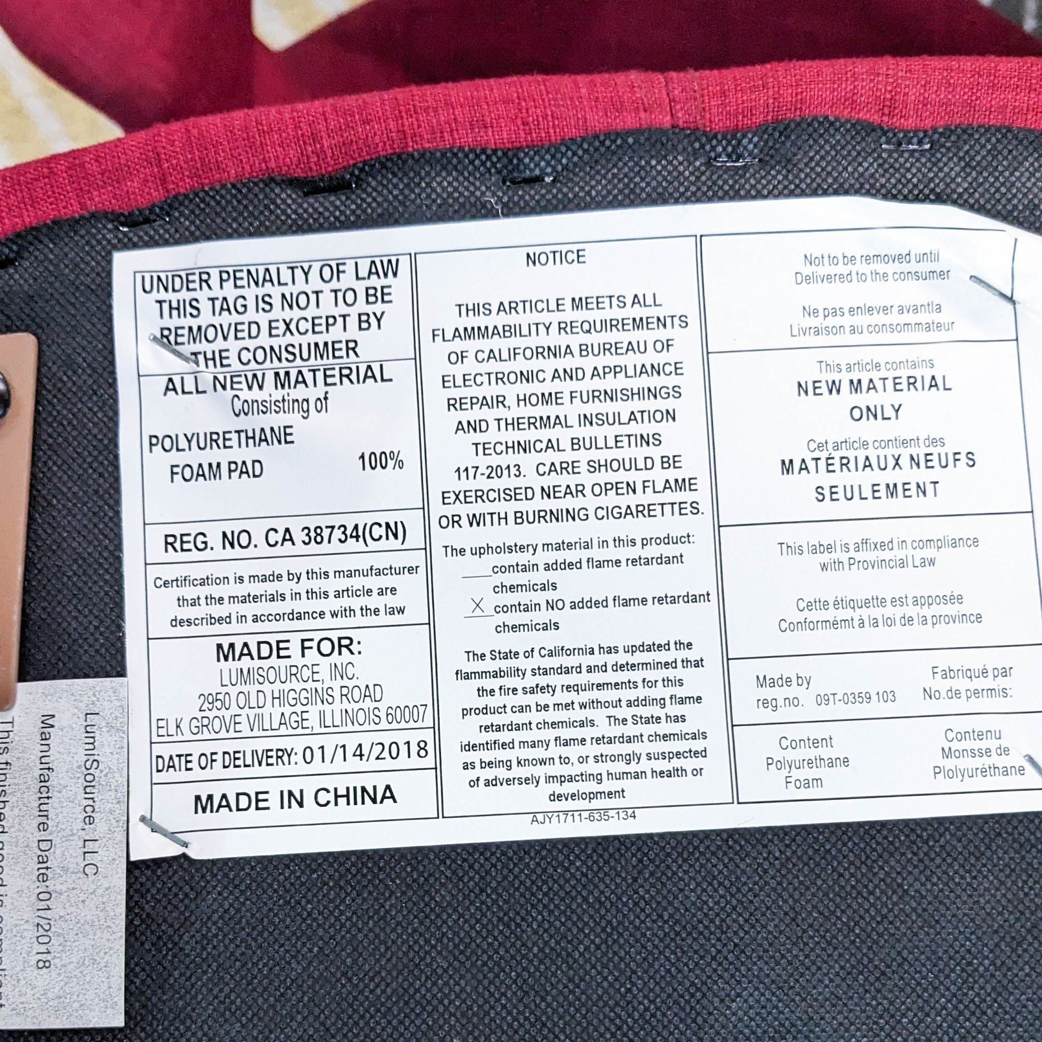 Close-up of a warning and material information label on a Vintage Flair Chair by LumiSource, indicating it's made of 100% polyurethane foam and meets flammability requirements.