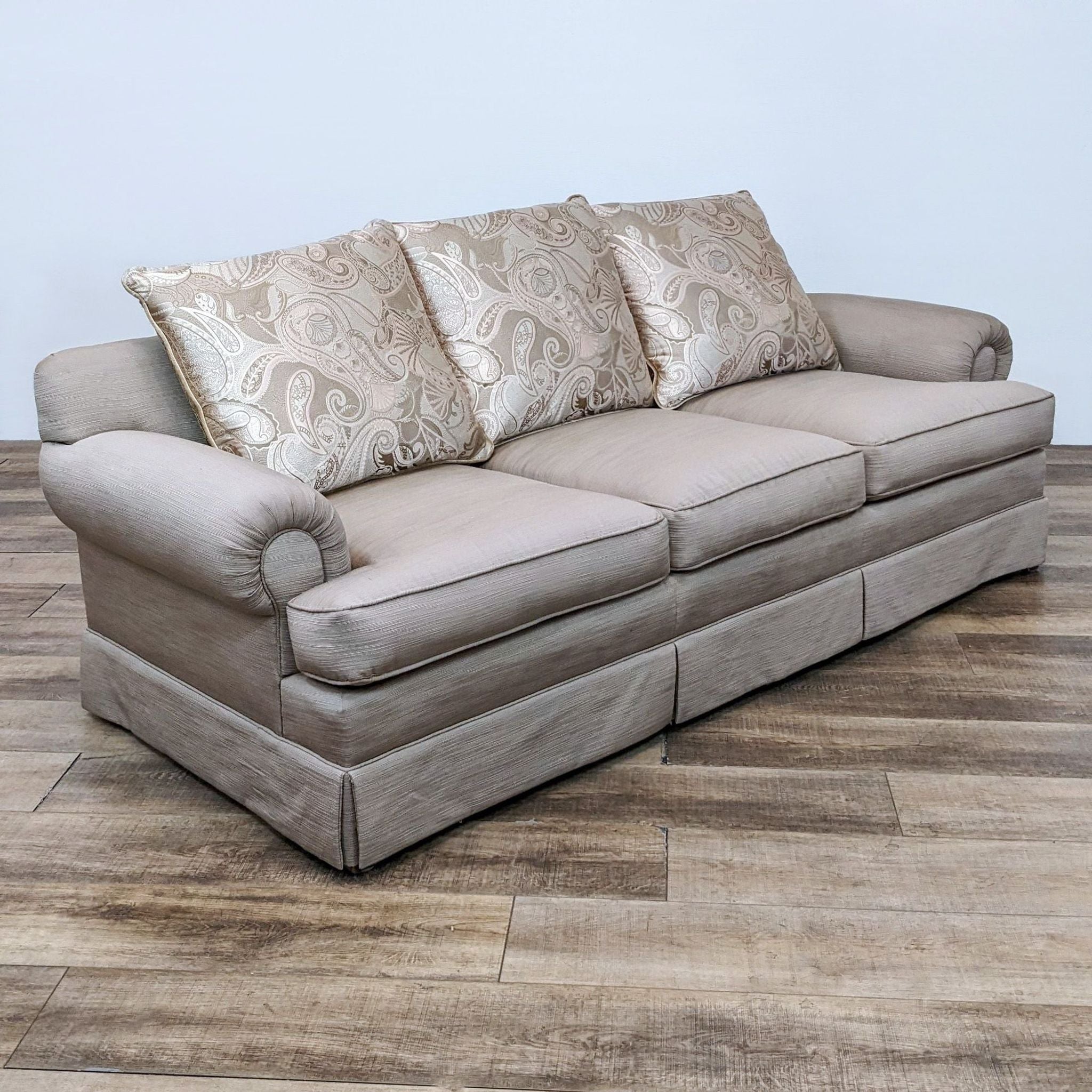 Front view of beige Reperch fabric sofa with three decorative back cushions.