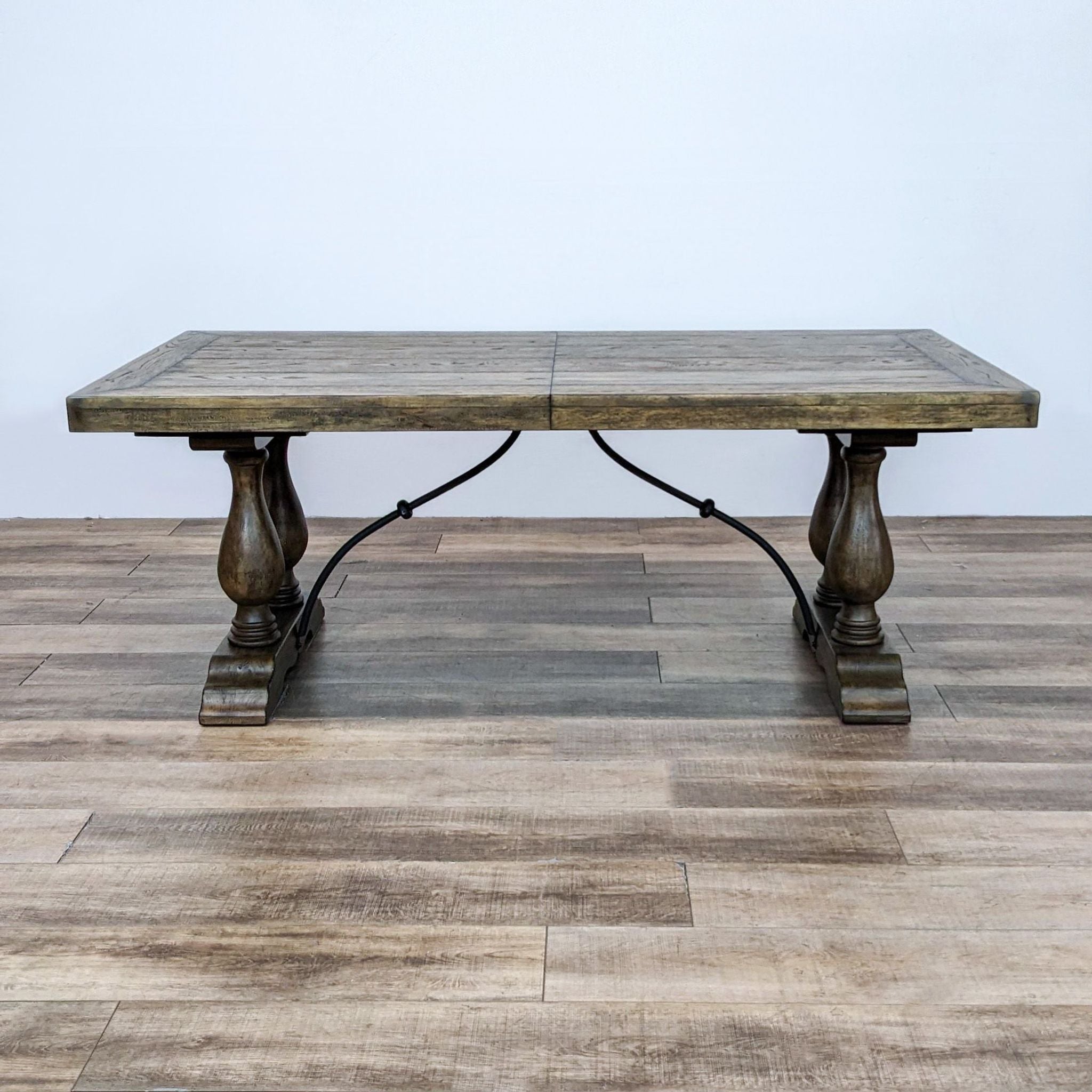 1. Pottery Barn's Loraine dining table, with traditional Spanish inspiration, showing dual pedestal bases and a serpentine metal brace.