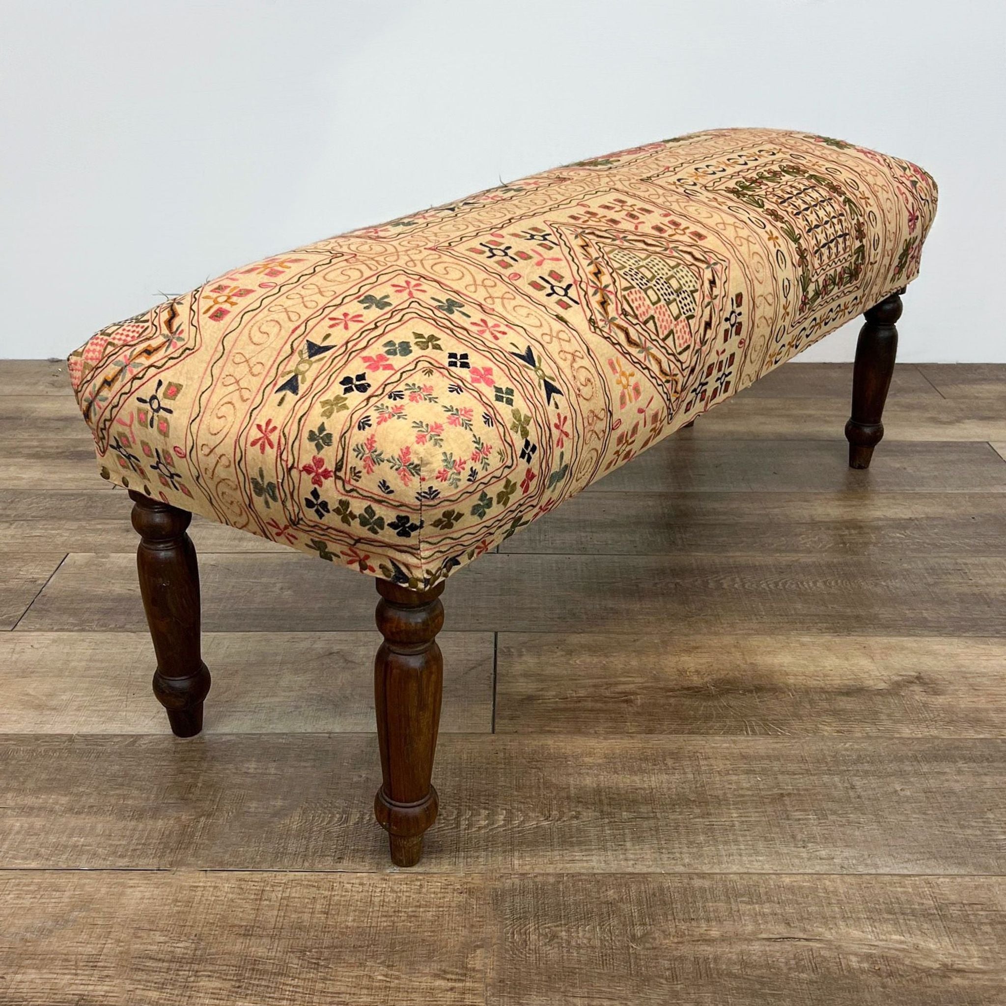 Patterned fabric Reperch padded bench on solid wood legs, showcasing intricate design.