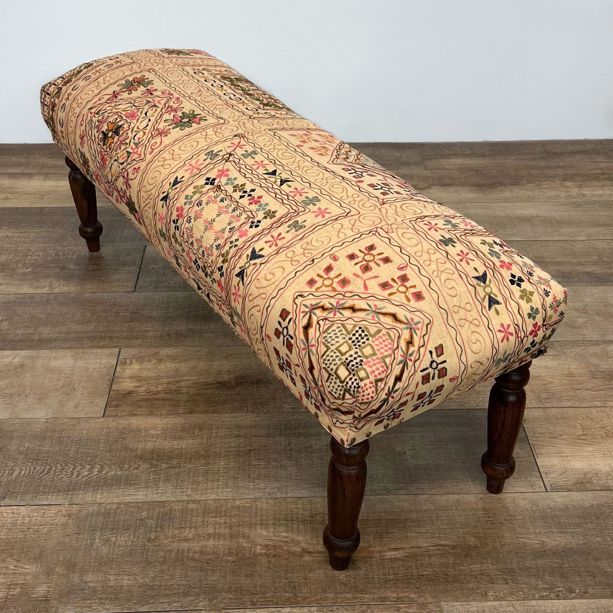 Whimsical fabric upholstered Reperch seat bench with patterned design on solid wood legs.