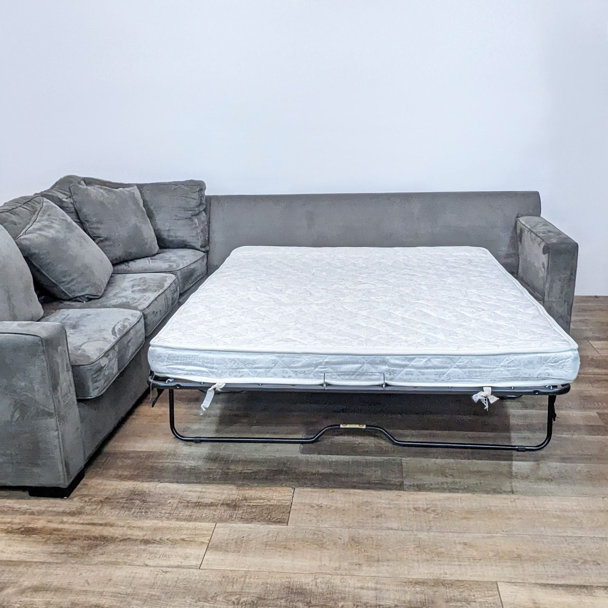 Alt text 2: "The same Scandinavian Designs sectional sofa with the queen sleeper component extended, showcasing the mattress, against a neutral backdrop."