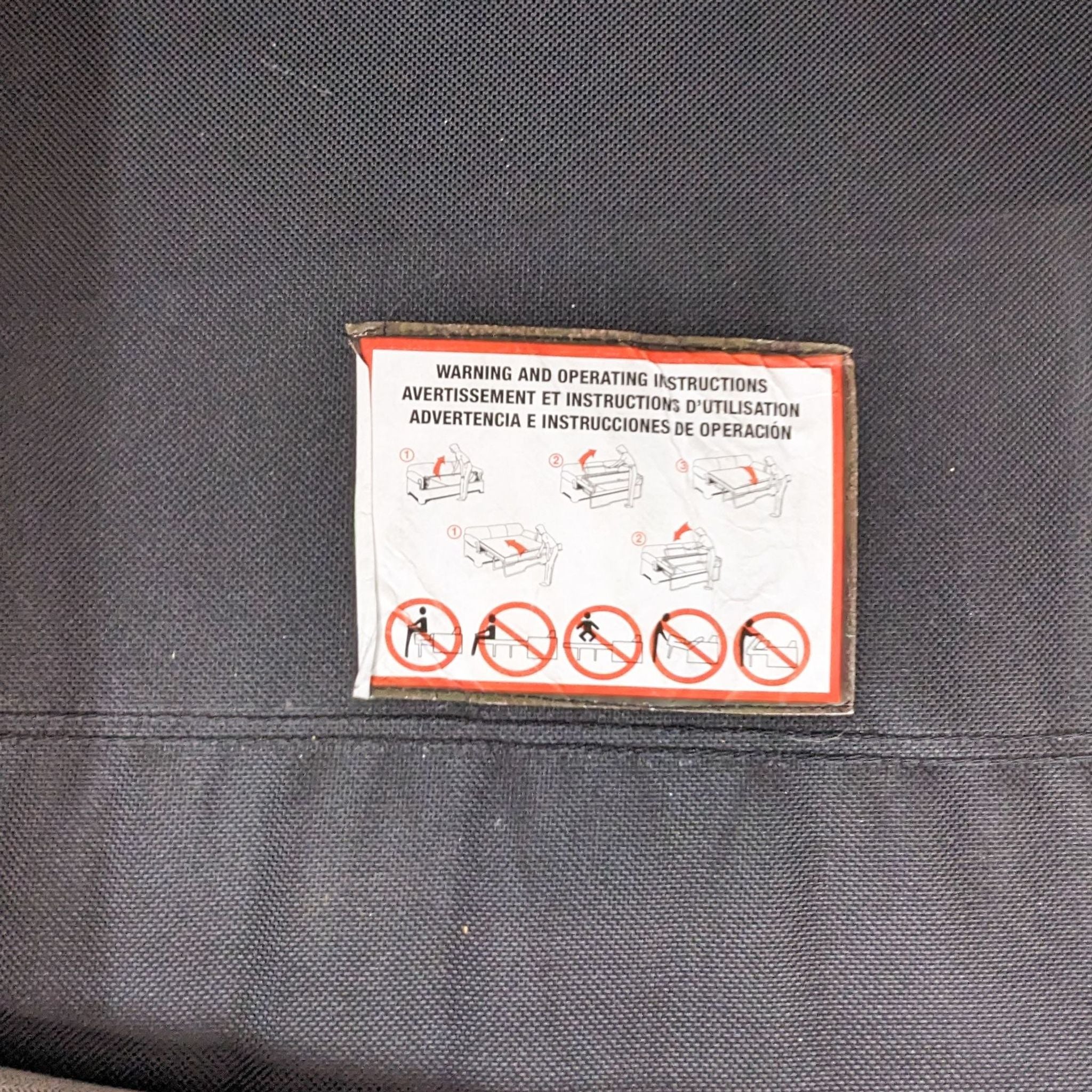 Alt text 3: "Close-up of a warning and operating instructions label on the Scandinavian Designs sectional with graphics depicting proper use."