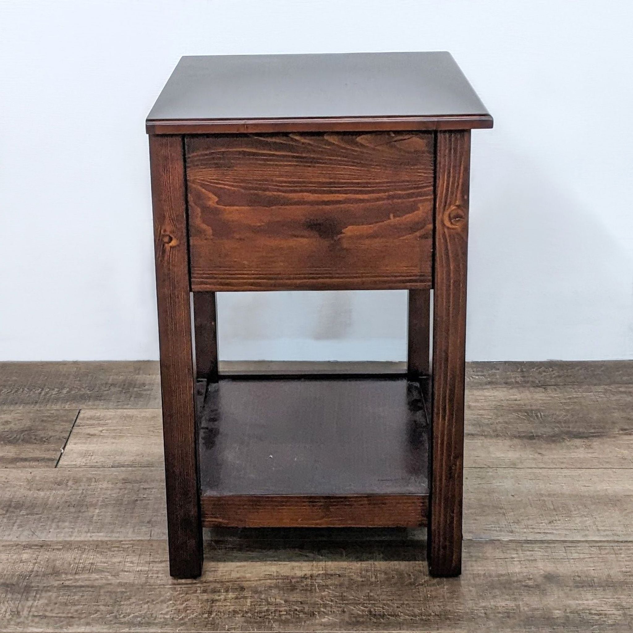 Brown Pottery Barn Kids end table featuring a single knobbed drawer, shown from an angled view to highlight its depth.