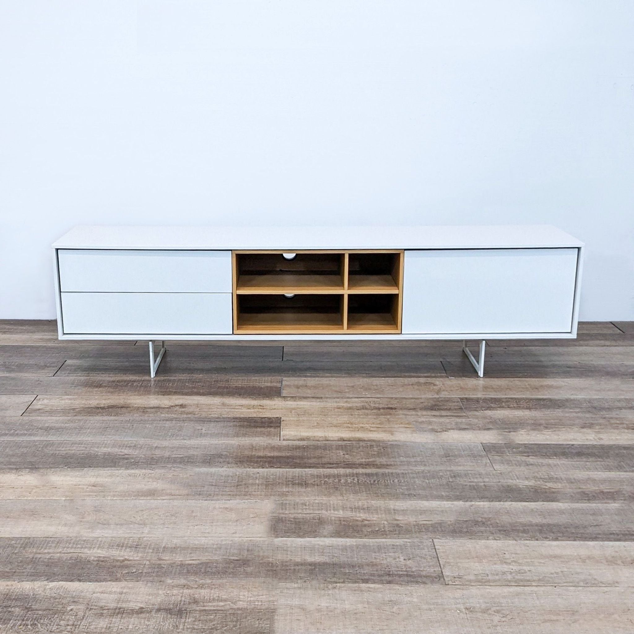 Treku Aura Media Unit with white lacquer, wood veneer finish, and steel base, showcasing a two-tone design with open shelving and drawers.