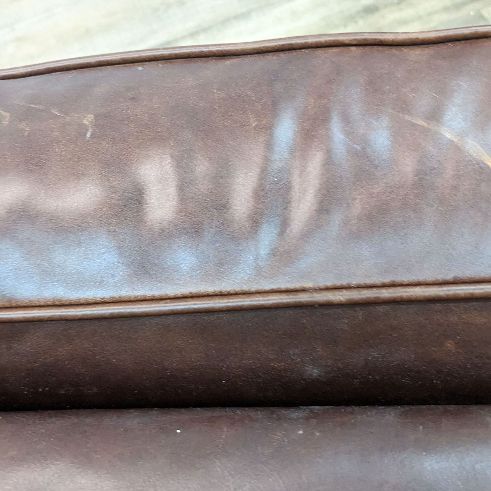 Close-up of a brown leather ottoman with nail head detailing by Henredon Leather Co.
