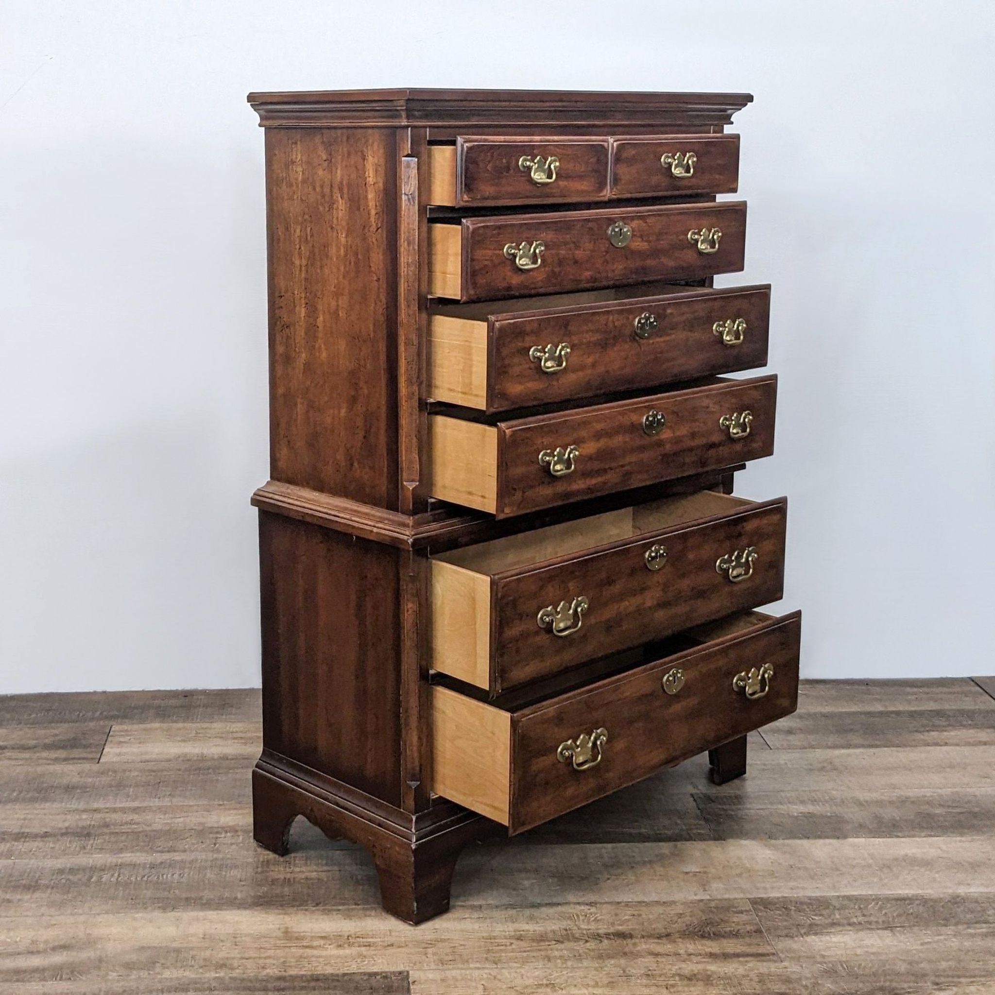 Six-drawer Reperch wooden highboy dresser, drawers partially open showing interior, antique brass pulls.