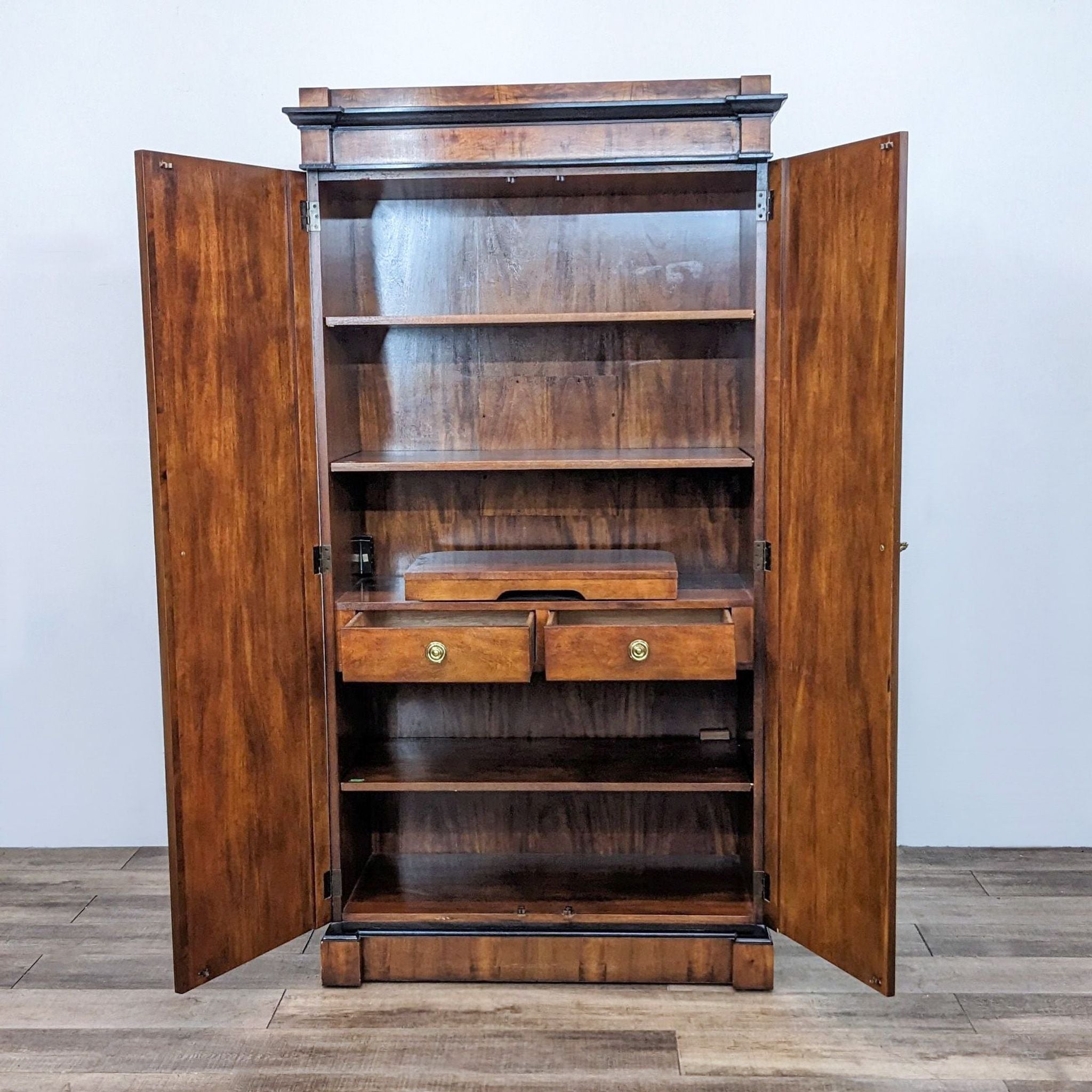 Interior view of the Century Furniture burlwood armoire showing shelves and two drawers, with doors open.