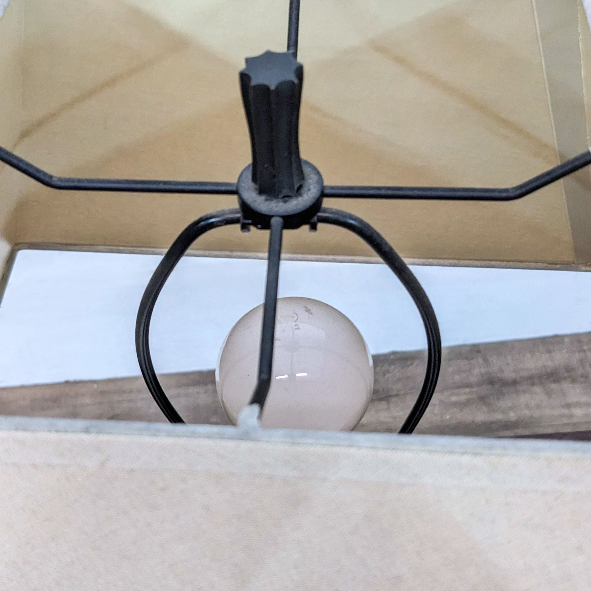3. Close-up of a Crate & Barrel lampshade's underside with a light bulb and metallic holder structure inside.