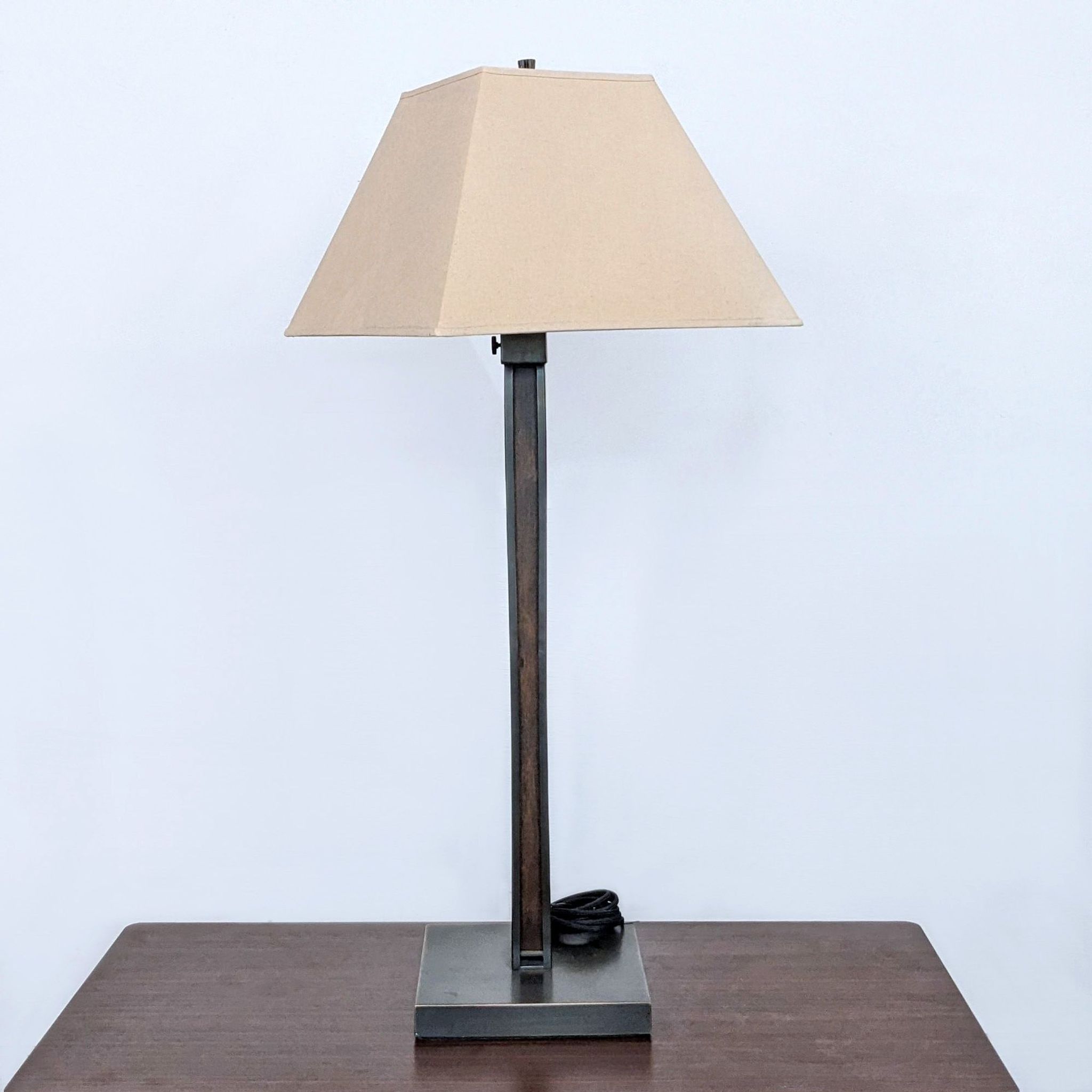 Reperch brand table lamp with a beige shade, brown stand, and square base on a wooden surface.