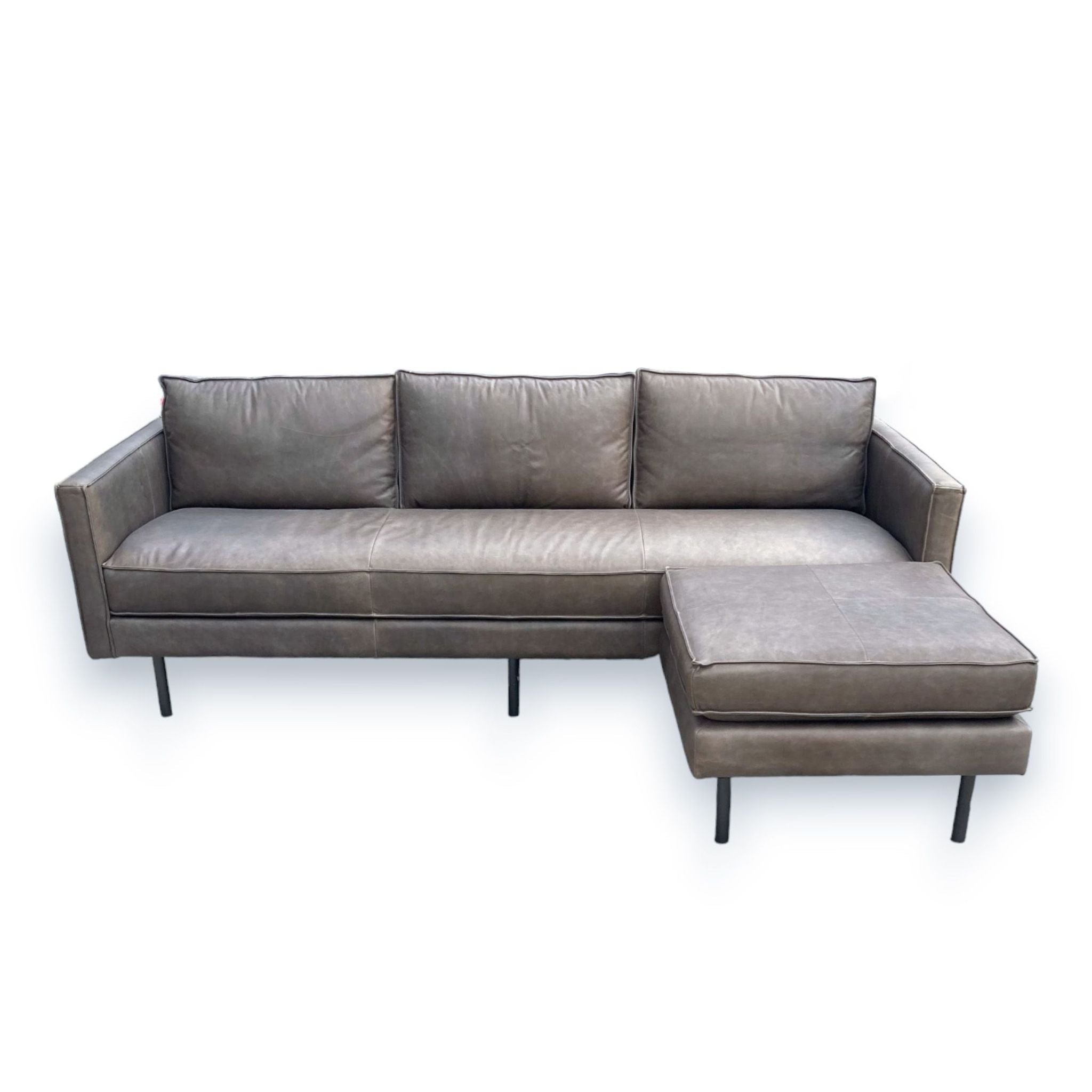 2. Axel Reversible Sectional by West Elm featuring flanged edges and a movable ottoman positioned as a chaise, in a leather finish.