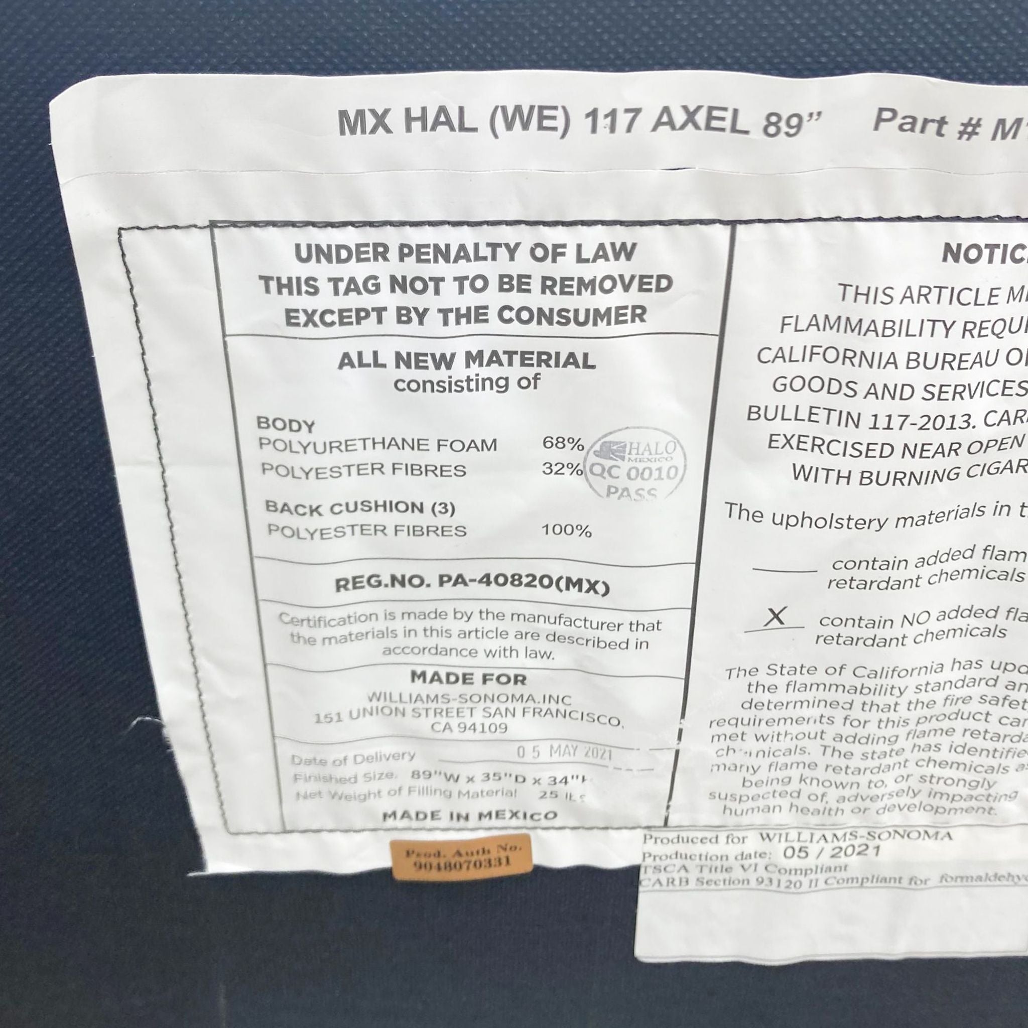 Close-up of a legal tag on a Williams-Sonoma leather sofa detailing materials, compliance information, and manufacturing details.