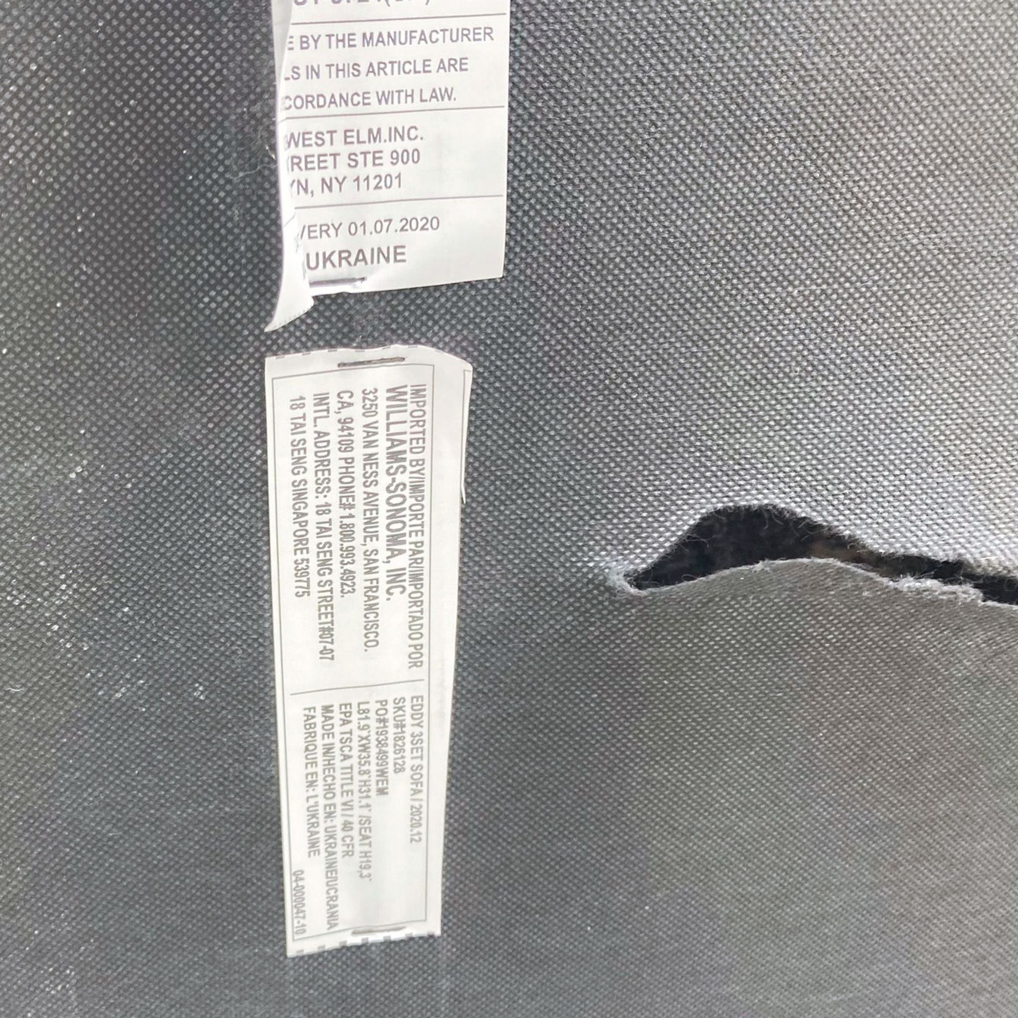 Alt text 2: Close-up of a West Elm sofa label showing materials and compliance information against a textured gray background.
