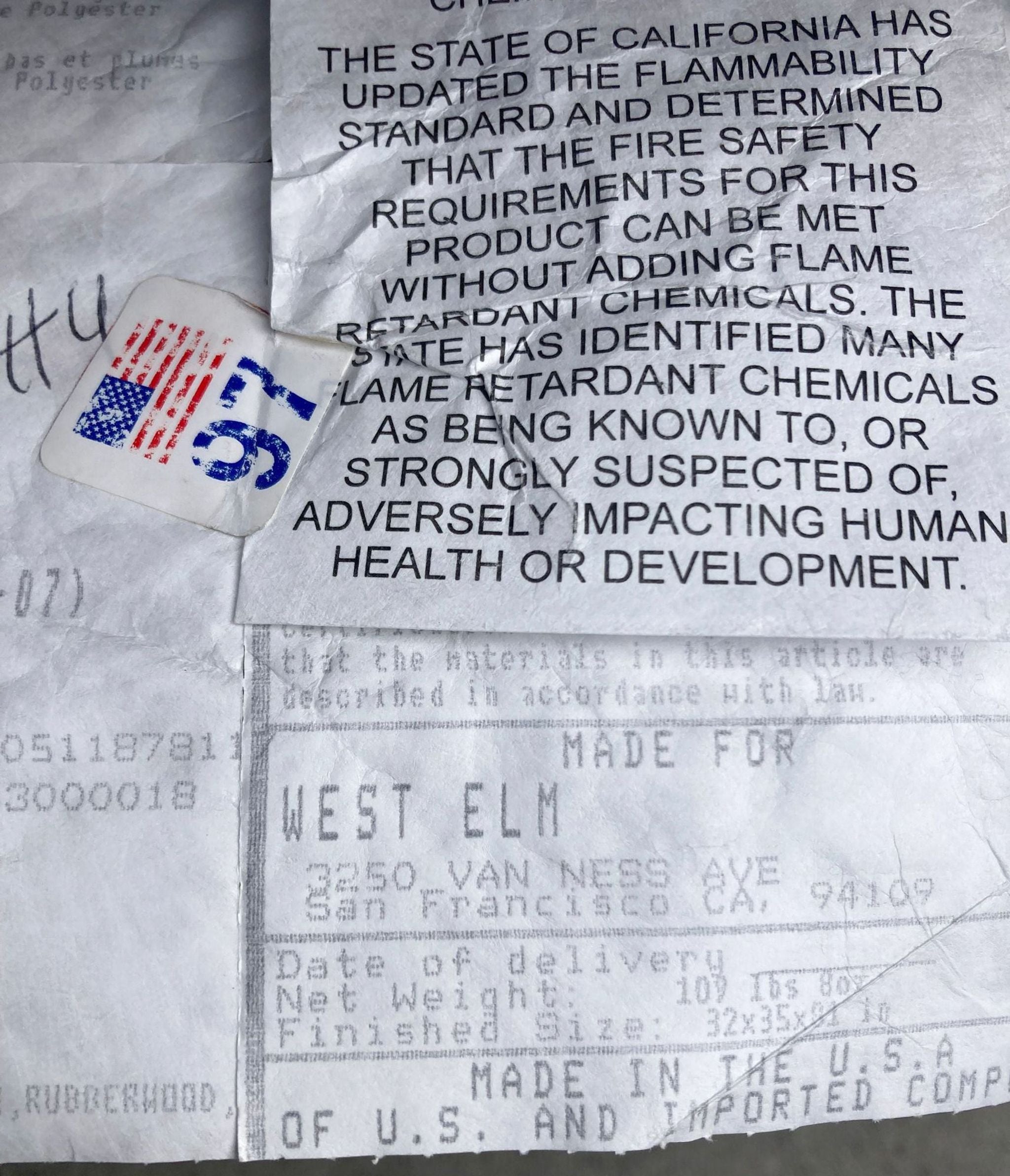 Torn label with text regarding California's flammability standard, warning about flame retardant chemicals, and brand details for West Elm's Hamilton Sofa.