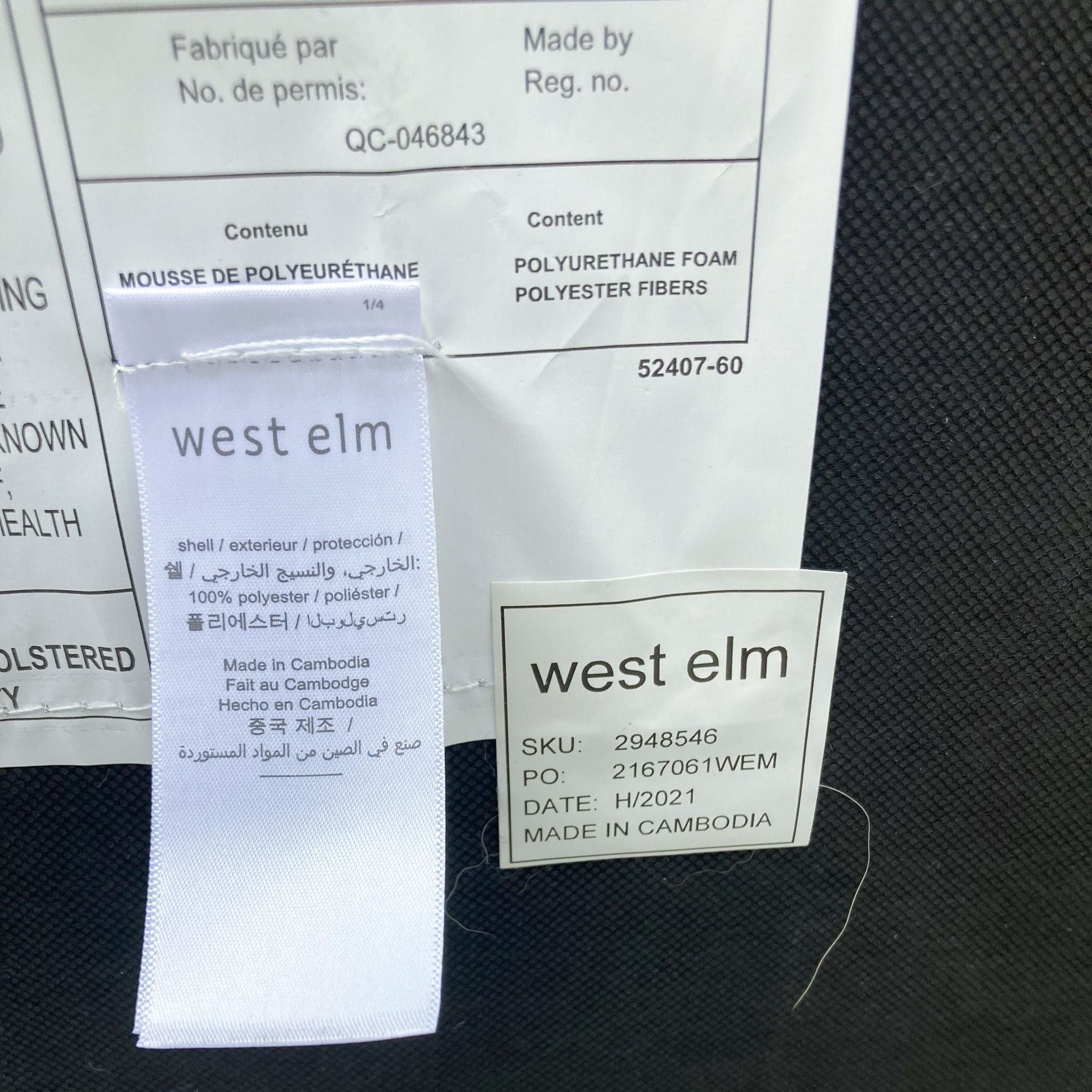 Label with West Elm logo on a grey fabric sofa showing material details and manufacturing information.