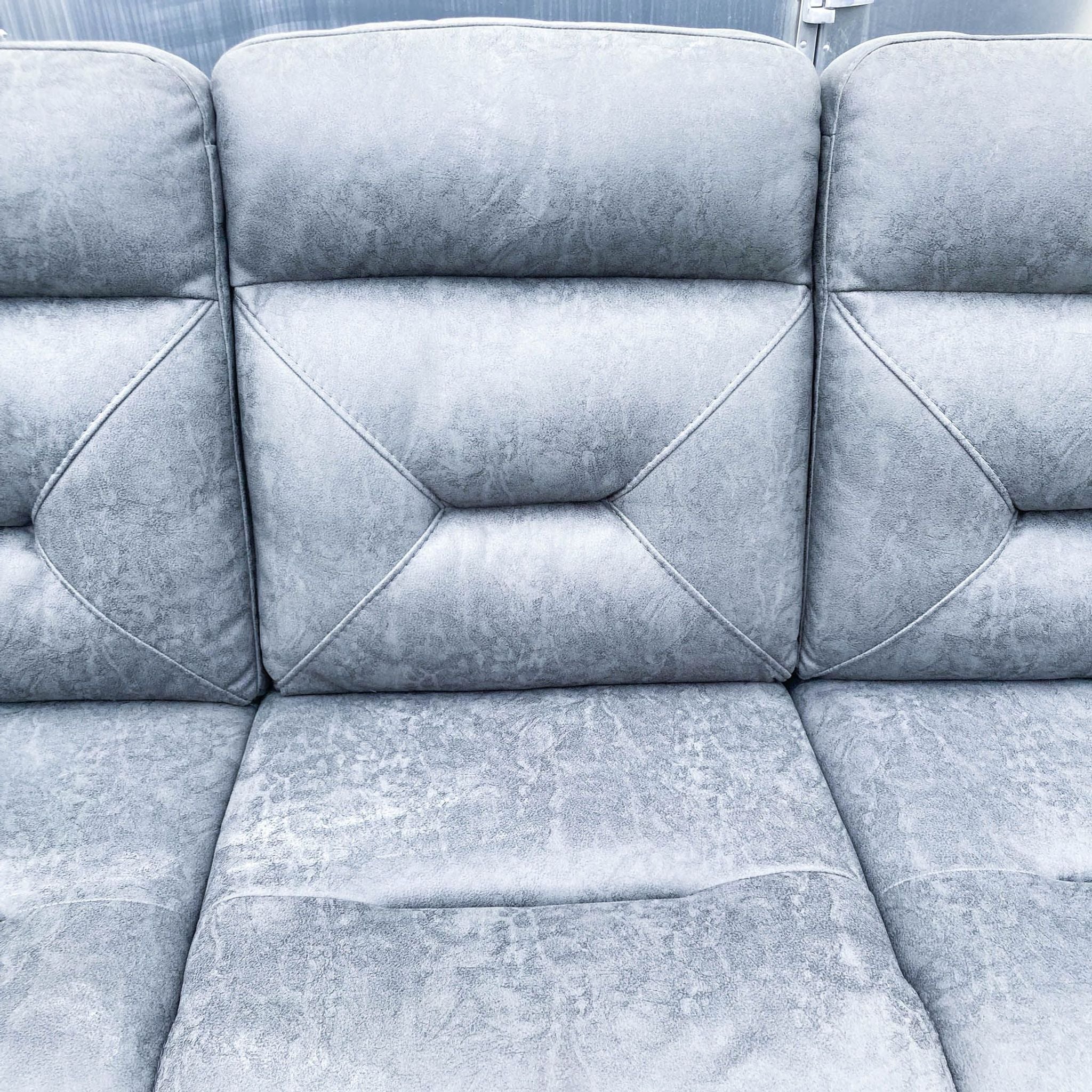 Detailed view of Reperch gray sofa's quilted back cushioning, highlighting comfort design.