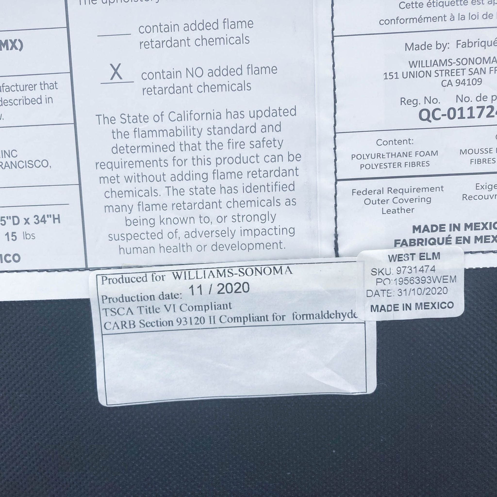 Close-up of manufacturing label on West Elm lounge chair, detailing production date and regulatory compliance.