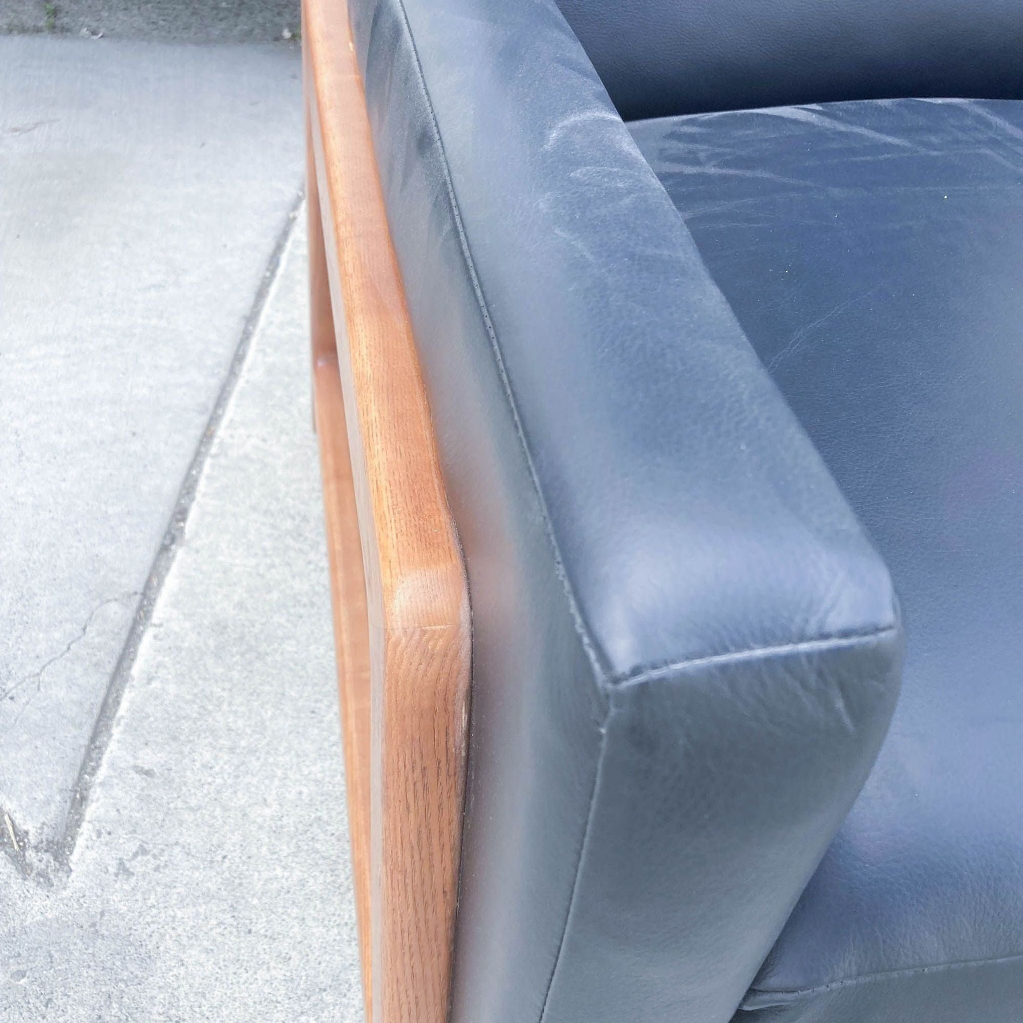 Close-up of the West Elm leather recliner showcasing the quality leather upholstery and the detailed wood frame.