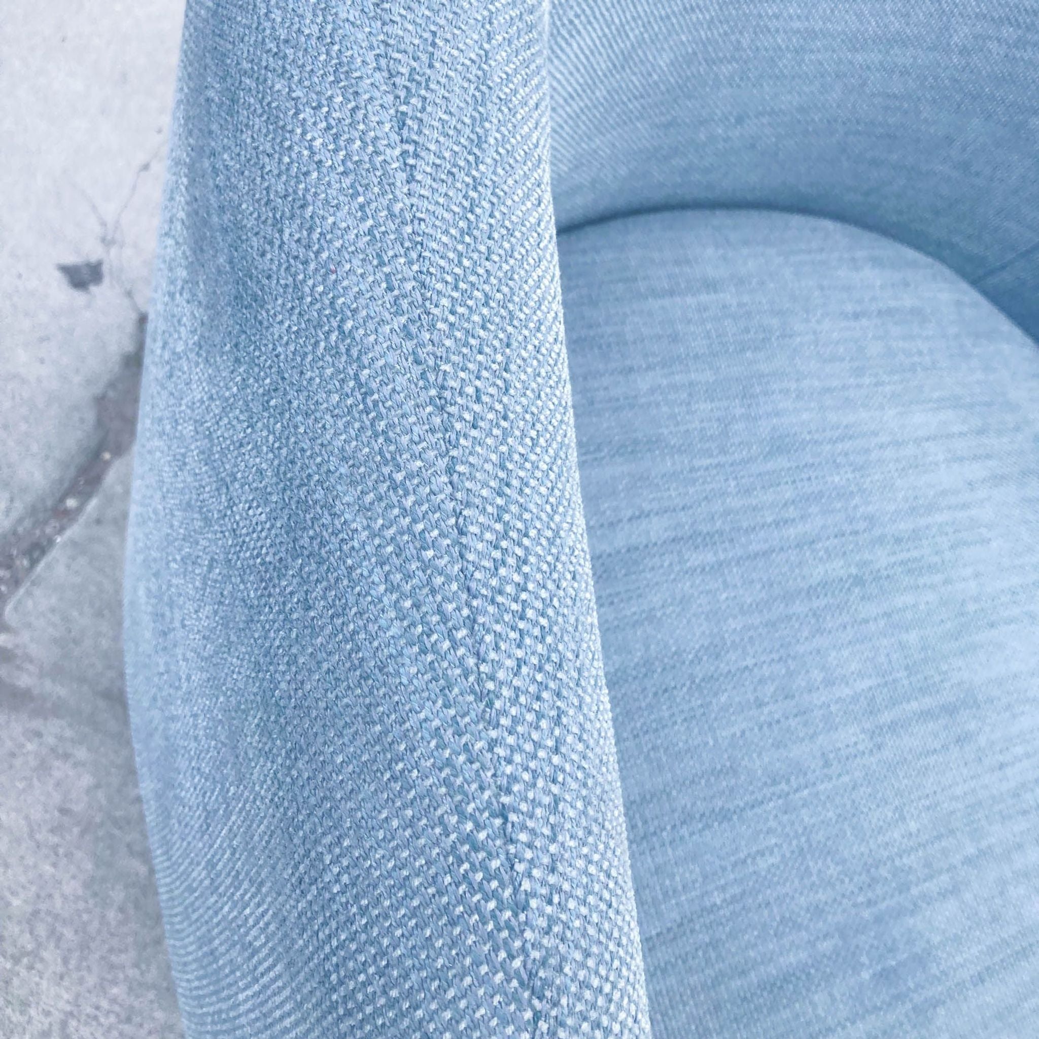 2. Close-up of the Crescent lounge chair's textured blue upholstery by West Elm, highlighting the weave fabric.