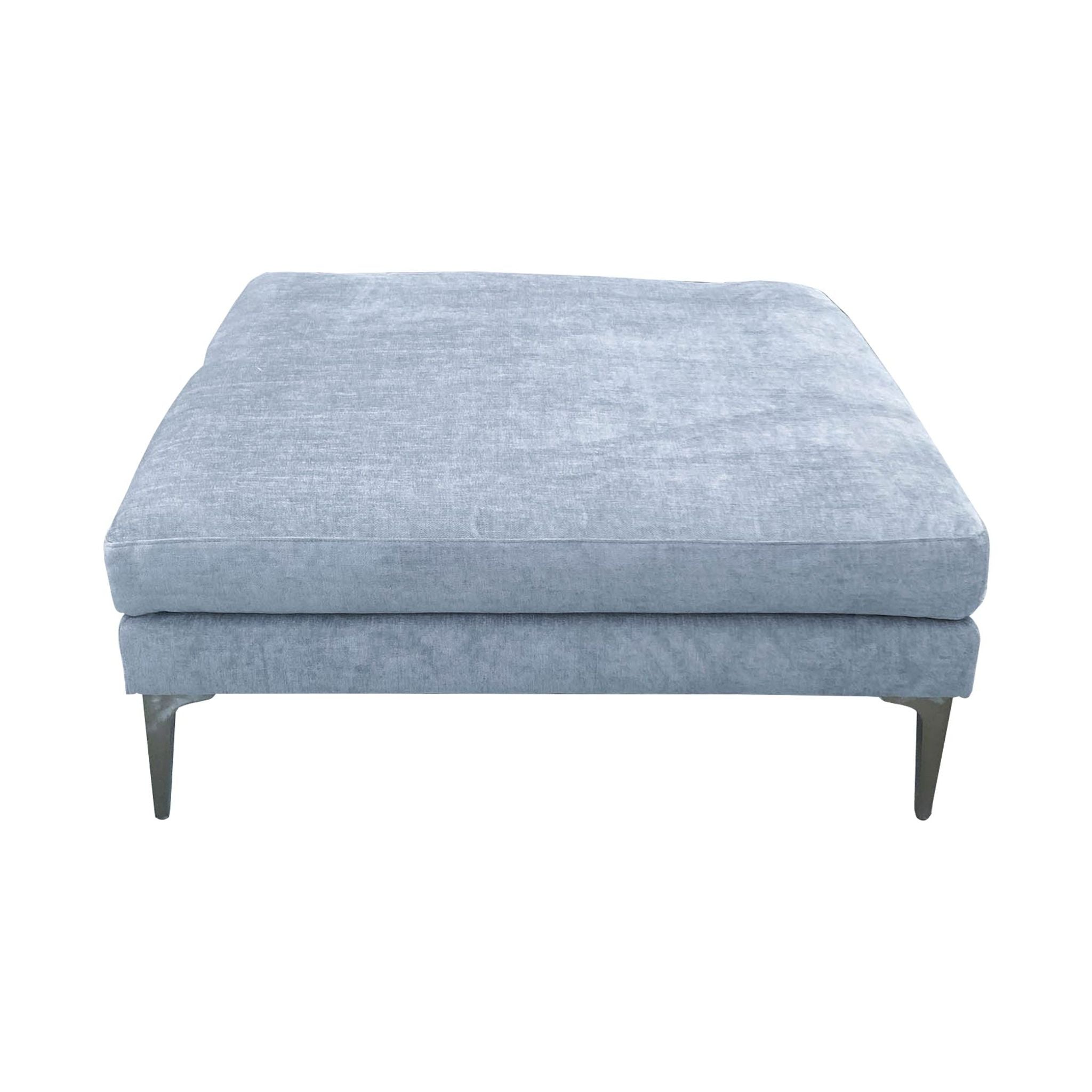 2. Modern Andes Ottoman by West Elm in mineral grey with a velvet finish and unique metal legs for a chic look.